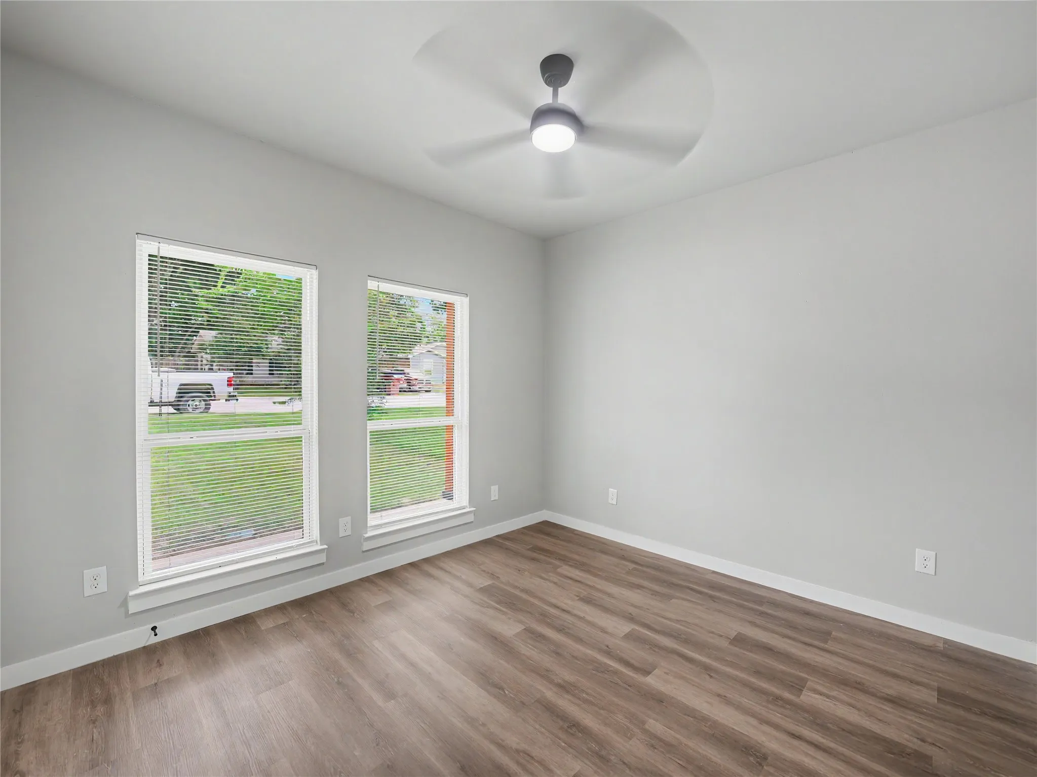 Interior space featuring wood-finish flooring, light gray wall paint, and white trim