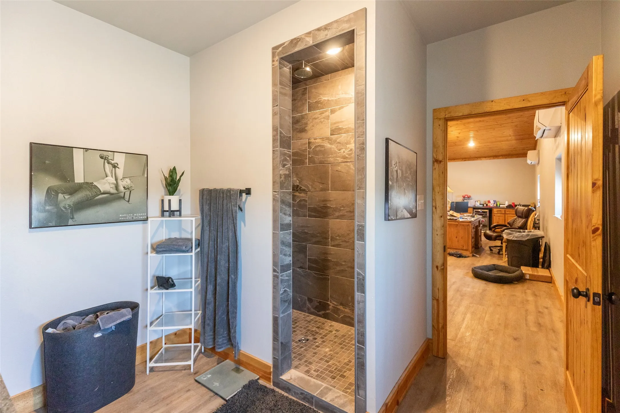 Walk-in shower featuring large format tile surrounds and a mosaic tile floor