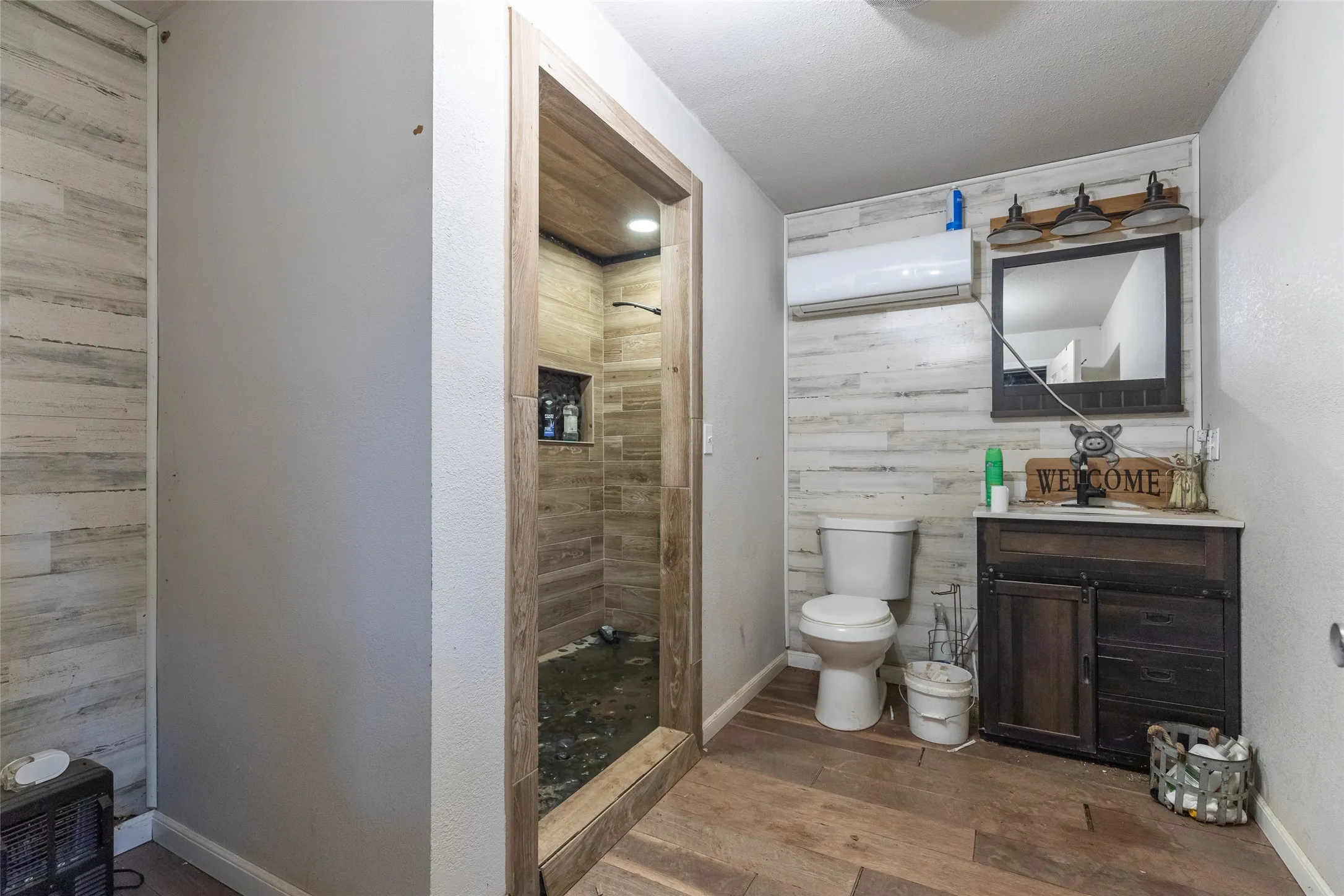 Walk-in shower with wood-finish tile surround and recessed niche