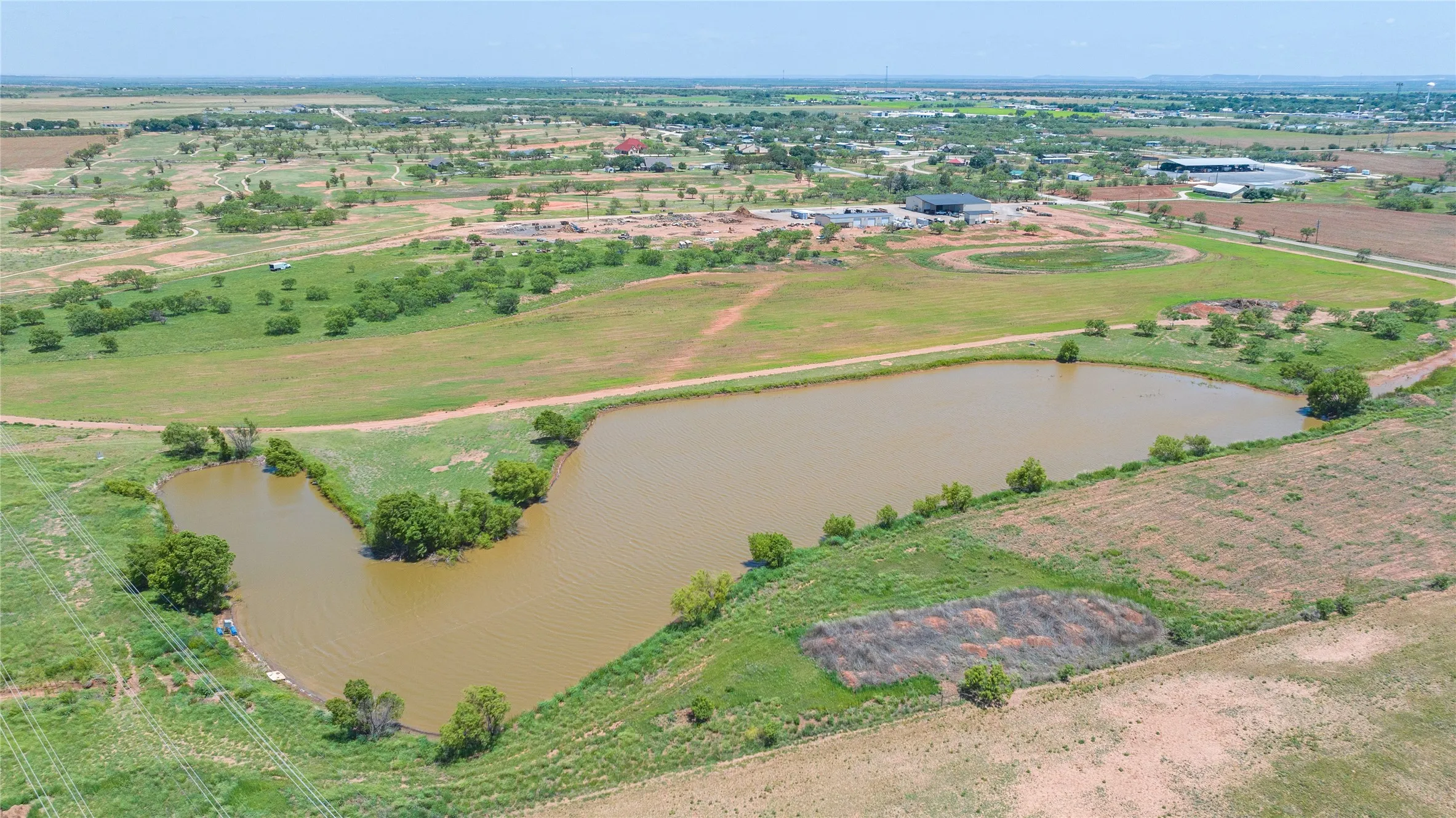 Expansive property featuring a large pond with a natural shoreline