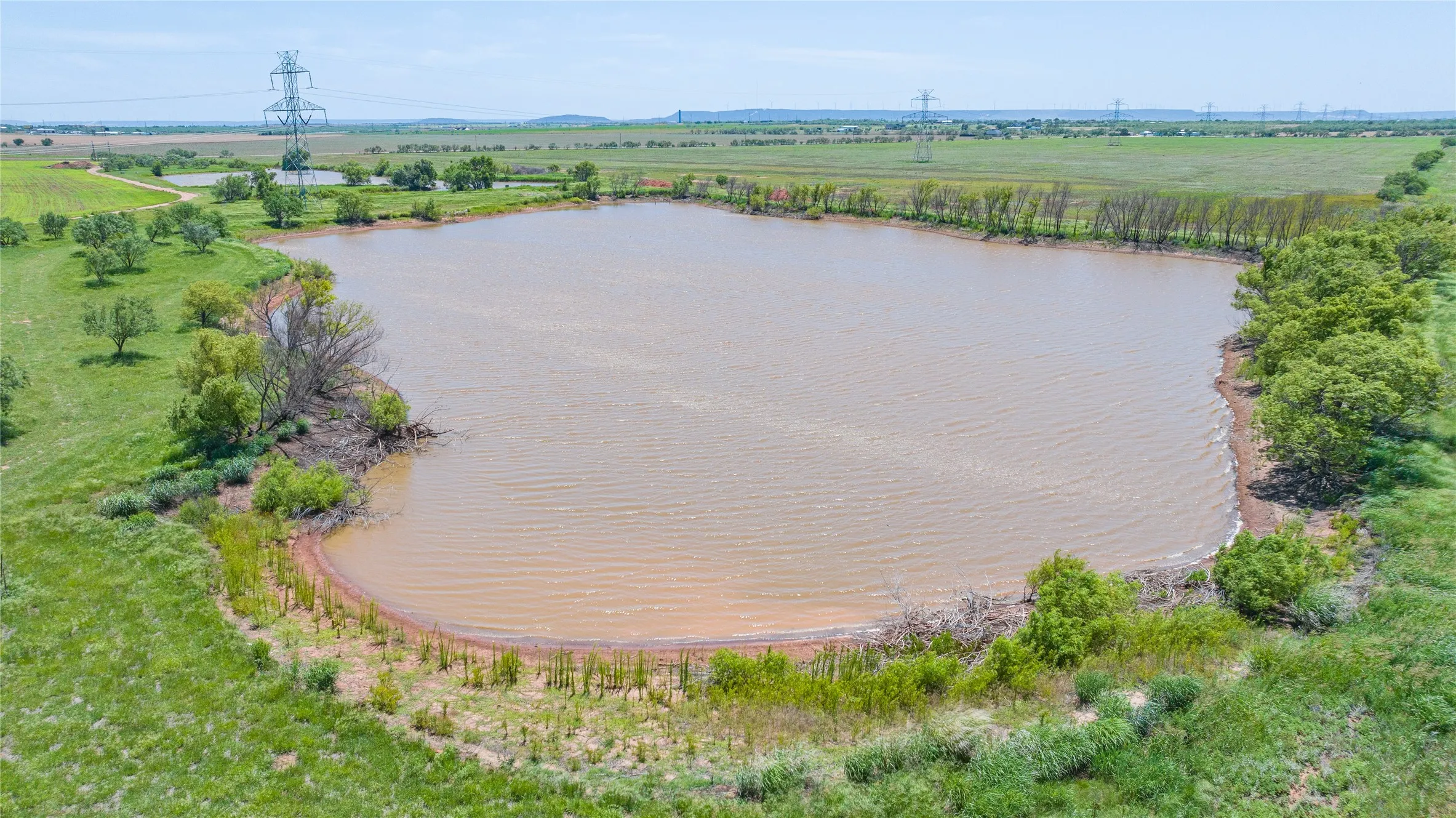 Expansive pond surrounded by lush green land