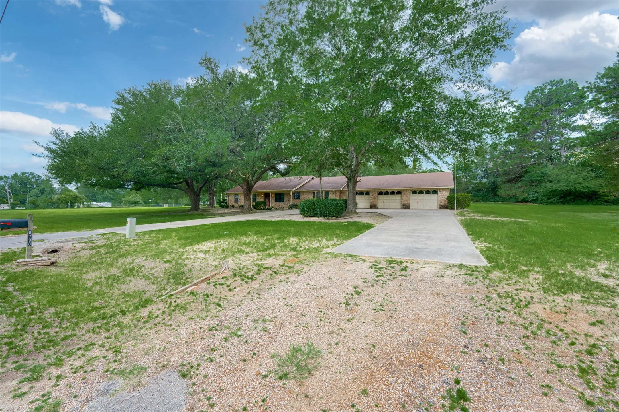 Ranch-style residence featuring a brick exterior and a three-car garage