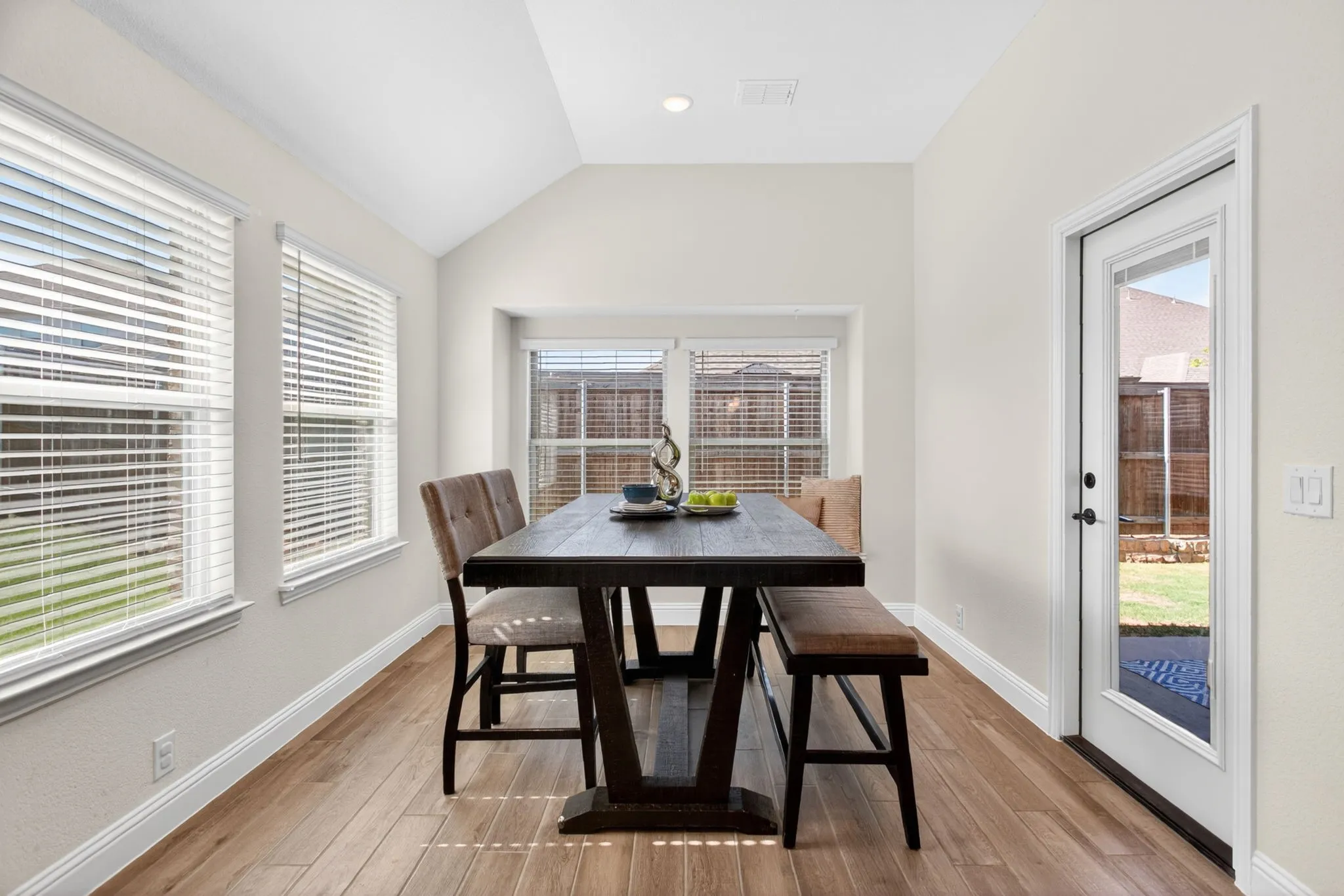 Generous breakfast nook with lots of windows, natural light, and a great window seat.