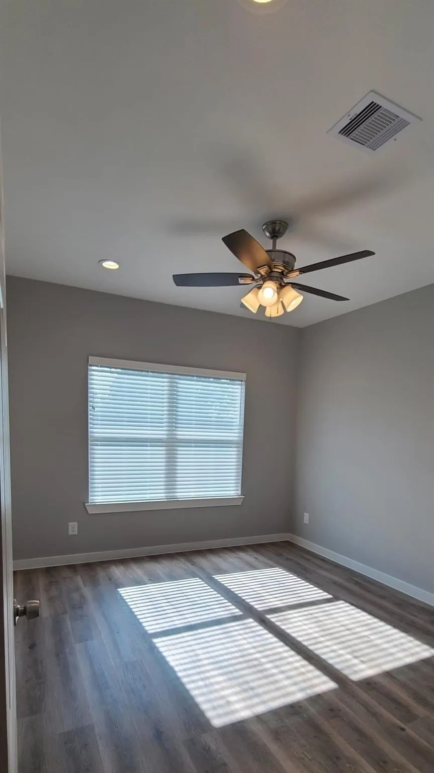 Bedroom 4 - featuring vinyl flooring, a window with horizontal blinds, recessed lighting, and a ceiling fan with integrated light