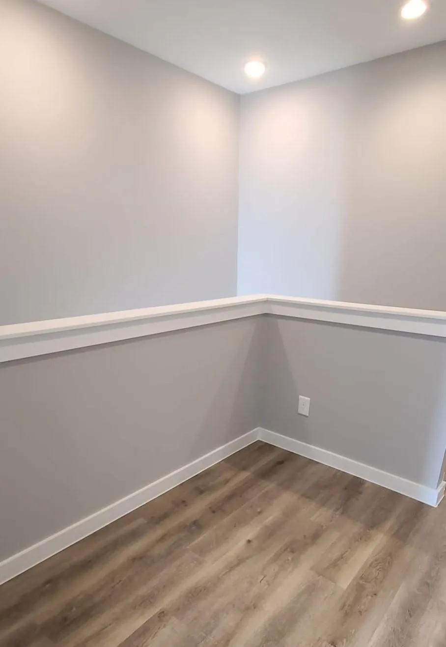 Recessed lighting illuminates this versatile space, featuring sleek flooring and modern trim.