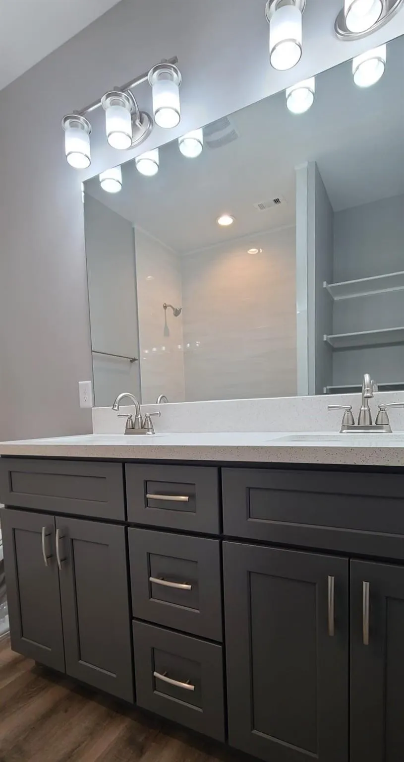 Bathroom 3 - Double vanity featuring dark cabinetry with brushed nickel hardware and a light-toned countertop