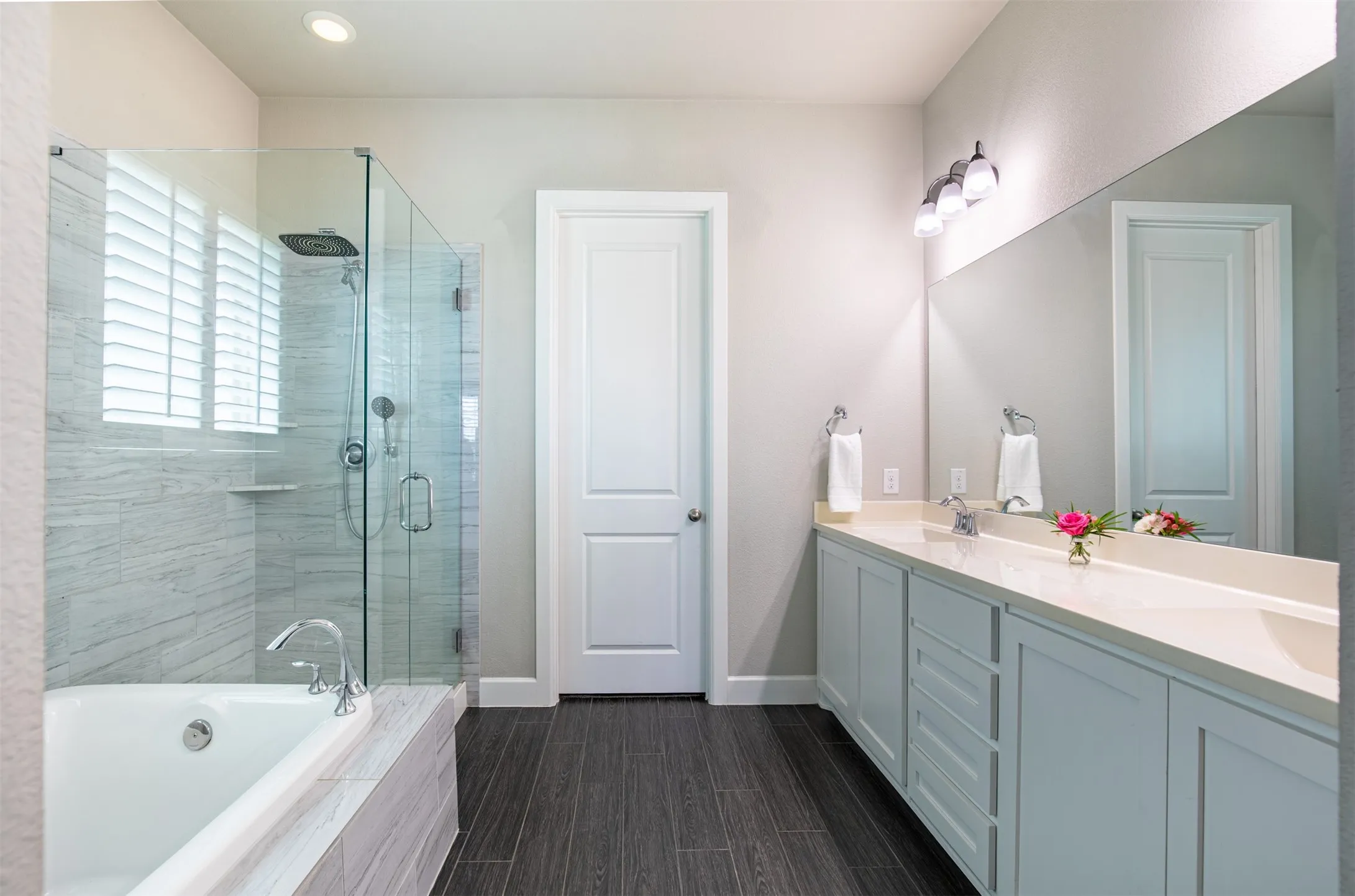 Spacious primary bathroom with walk-in glass shower, premium fixtures, and oversized walk-in closet.