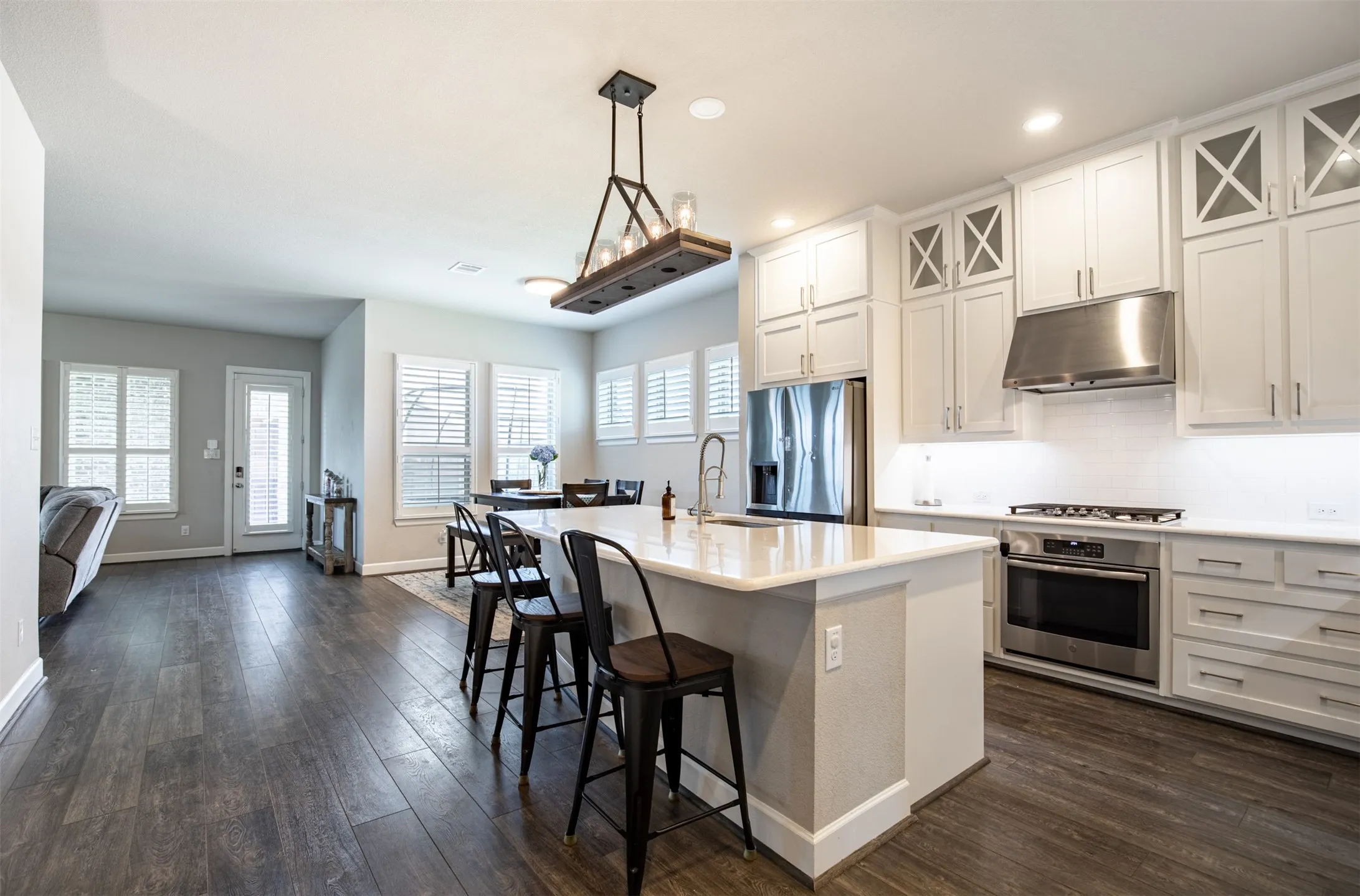 Spacious kitchen highlighting custom full-height cabinets and elegant decorative feature lighting.