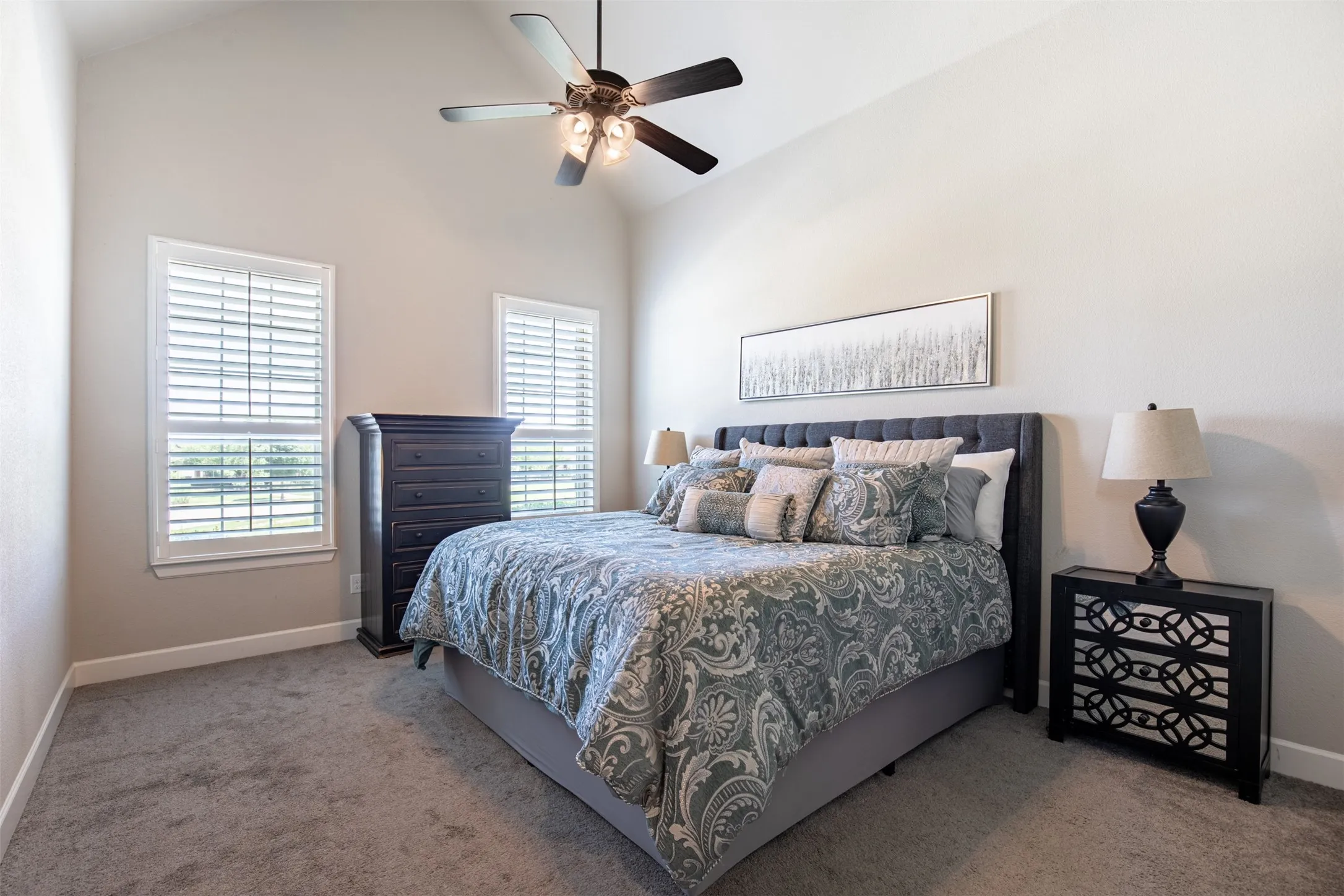 Spacious primary bedroom featuring large, sun-drenched windows with custom, high-end plantation shutters for added privacy and timeless elegance.