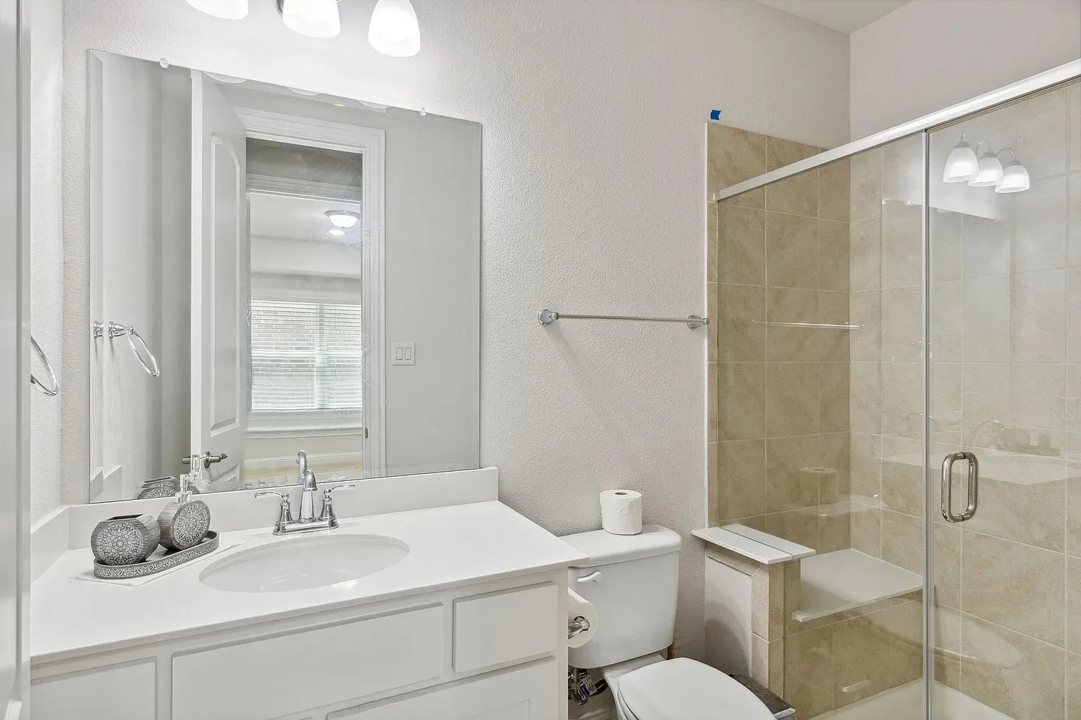 Full bathroom featuring an enclosed shower with light-toned tile surround and a built-in bench