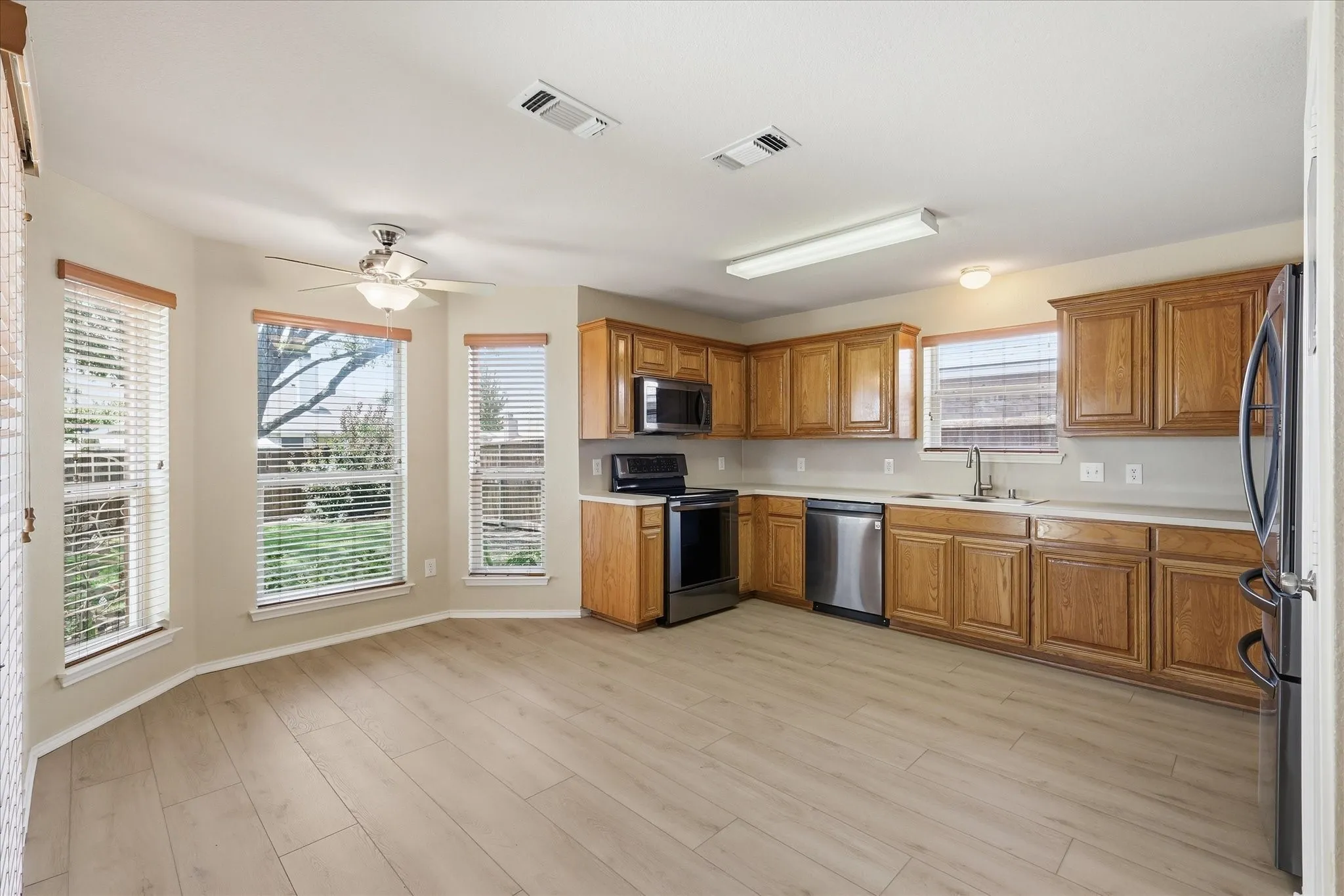 Kitchen featuring wood-finish flooring, oak cabinetry, and stainless steel appliances