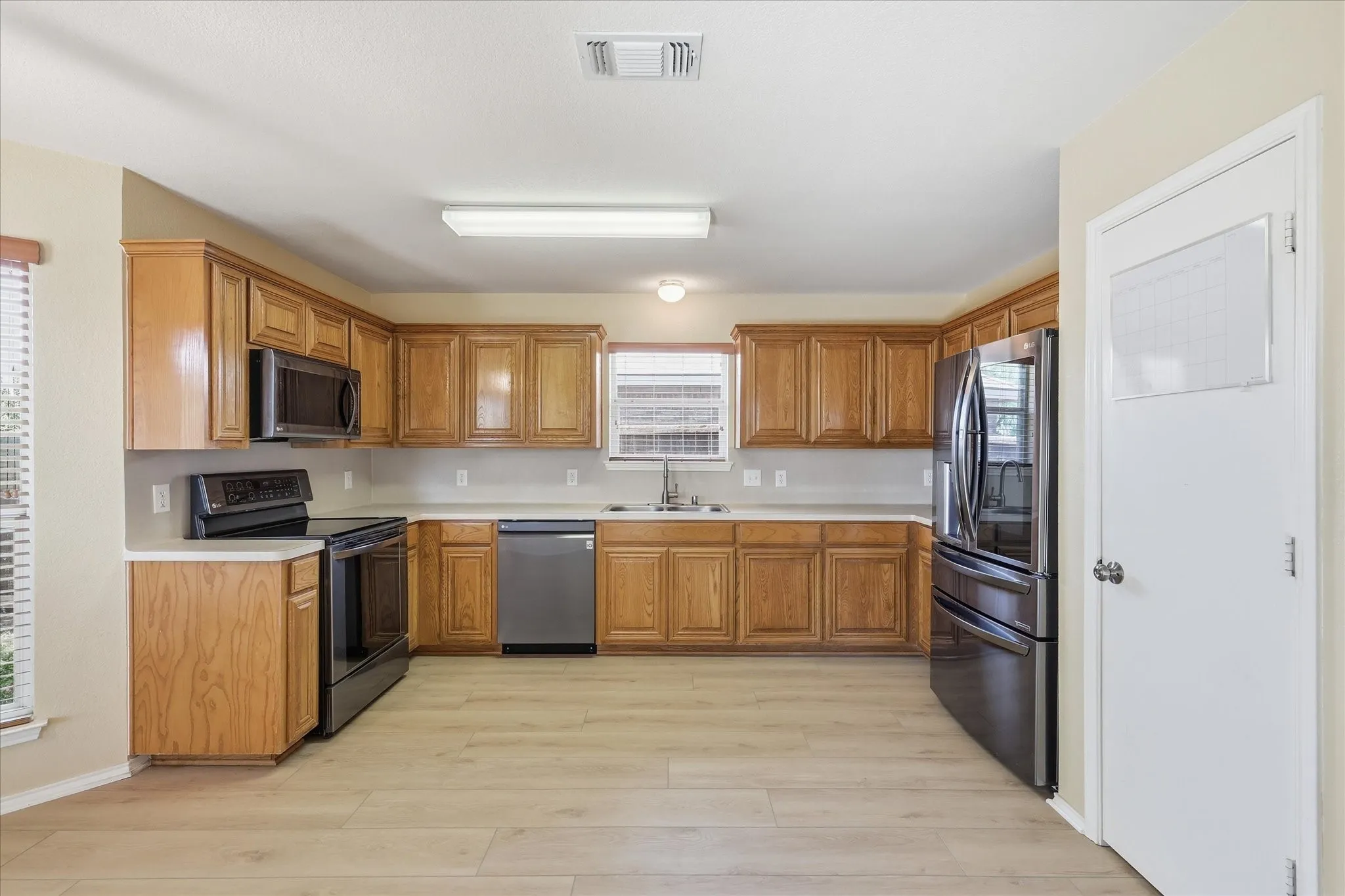 Kitchen featuring wood cabinetry, light countertops, and stainless steel appliances