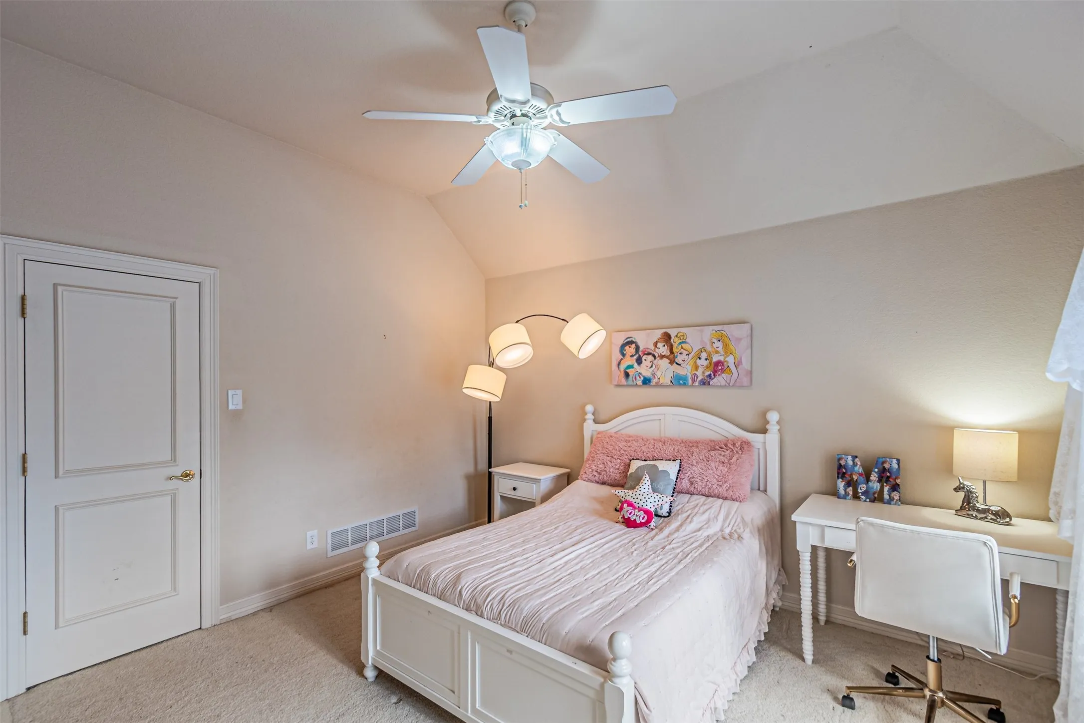 Carpeted room with a vaulted ceiling and ceiling fan