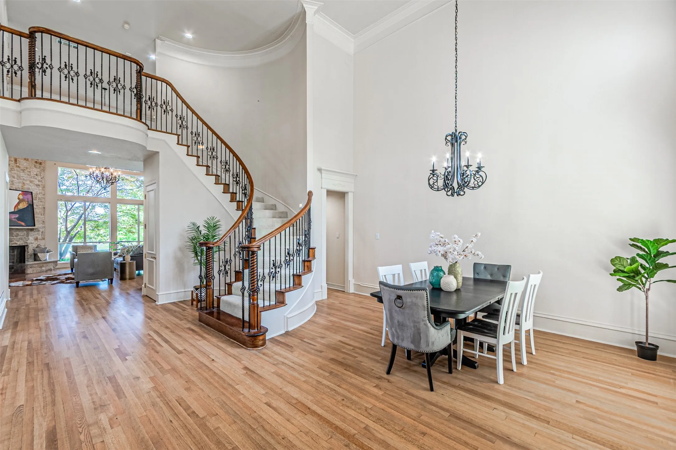 Grand curved staircase with dark wood handrails and decorative iron balusters