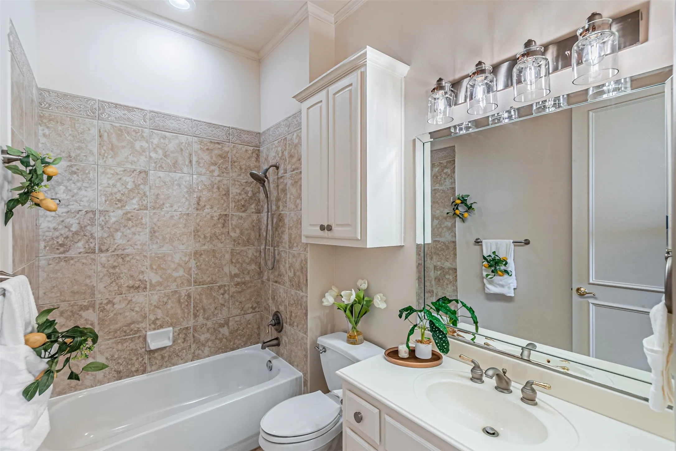 Bathroom featuring a full vanity with an integrated sink, polished chrome faucet, and a large mirror