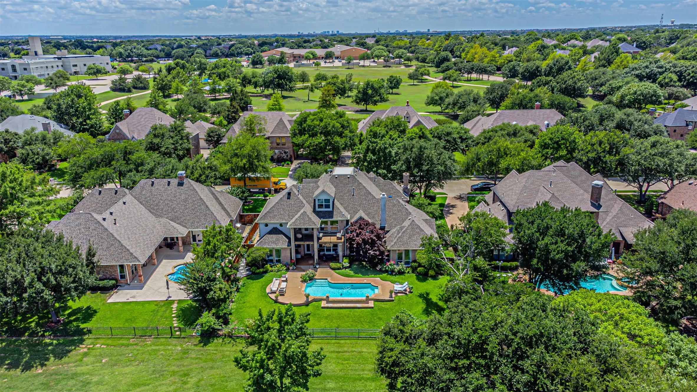 Sprawling property featuring a private swimming pool with an integrated spa, expansive green lawn, and mature landscaping
