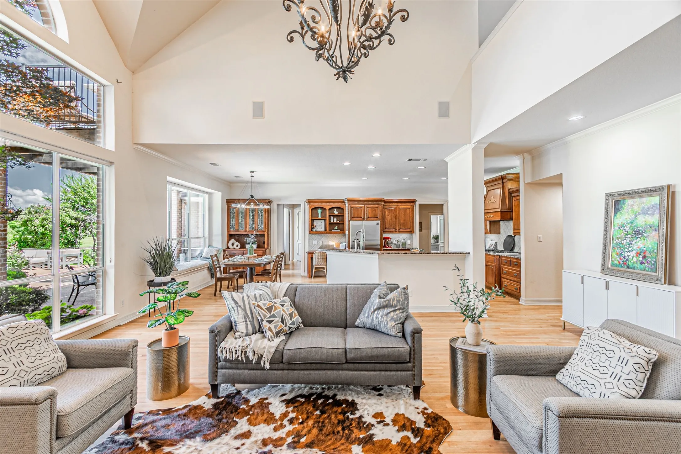Vaulted ceilings enhance this open-concept living area, featuring wood-finish flooring and large windows