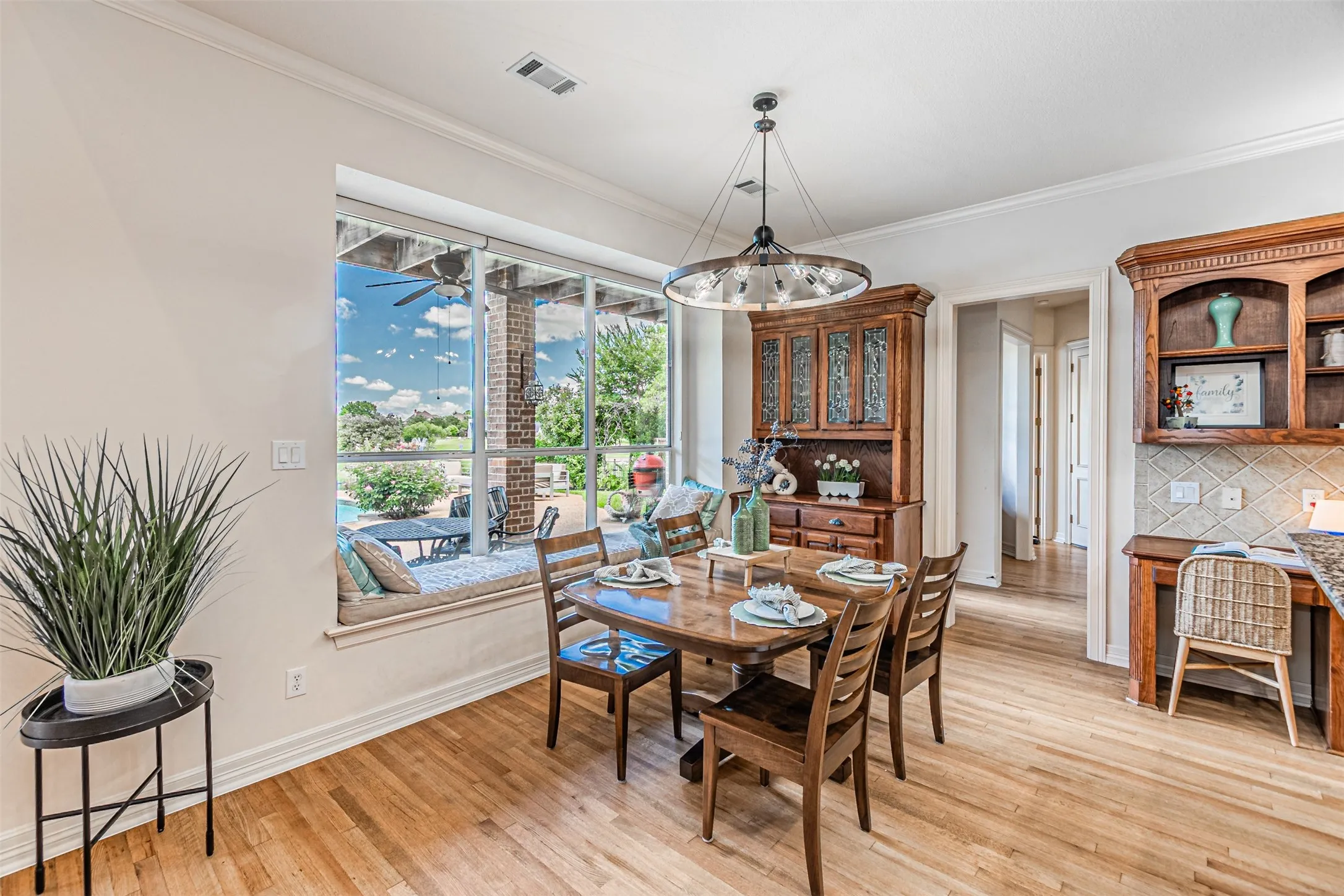 Dining area with wood-finish flooring and a large window featuring a built-in window seat