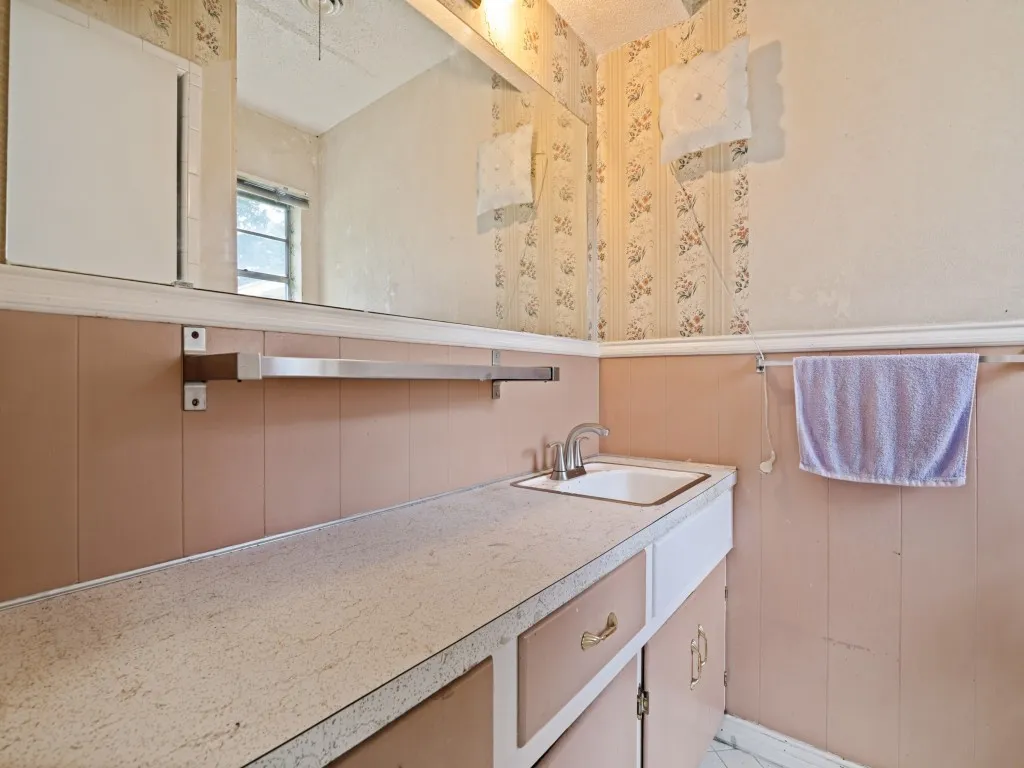Bathroom vanity with an integrated sink, laminate countertop, and wood-finish cabinetry