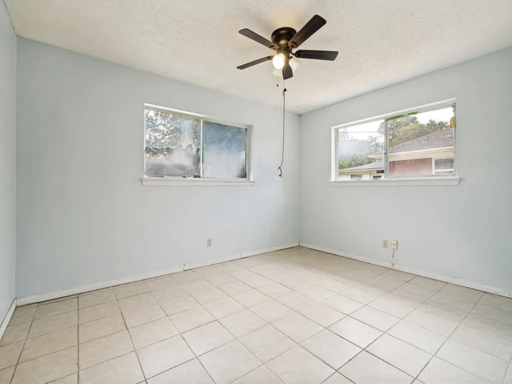 Interior space featuring light-toned tile flooring and pale blue walls