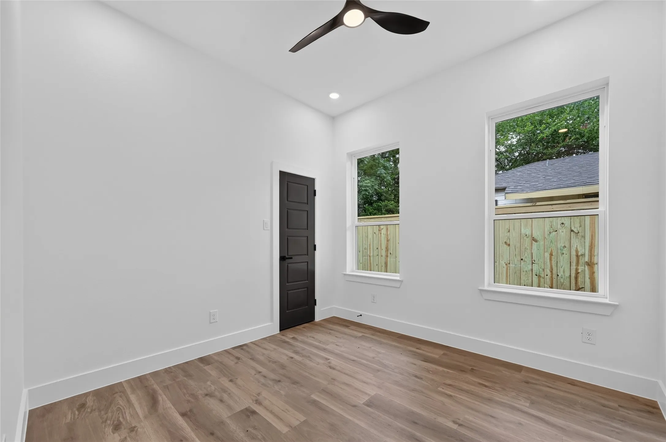 Room featuring light wood-finish flooring, white baseboards, and bright white walls