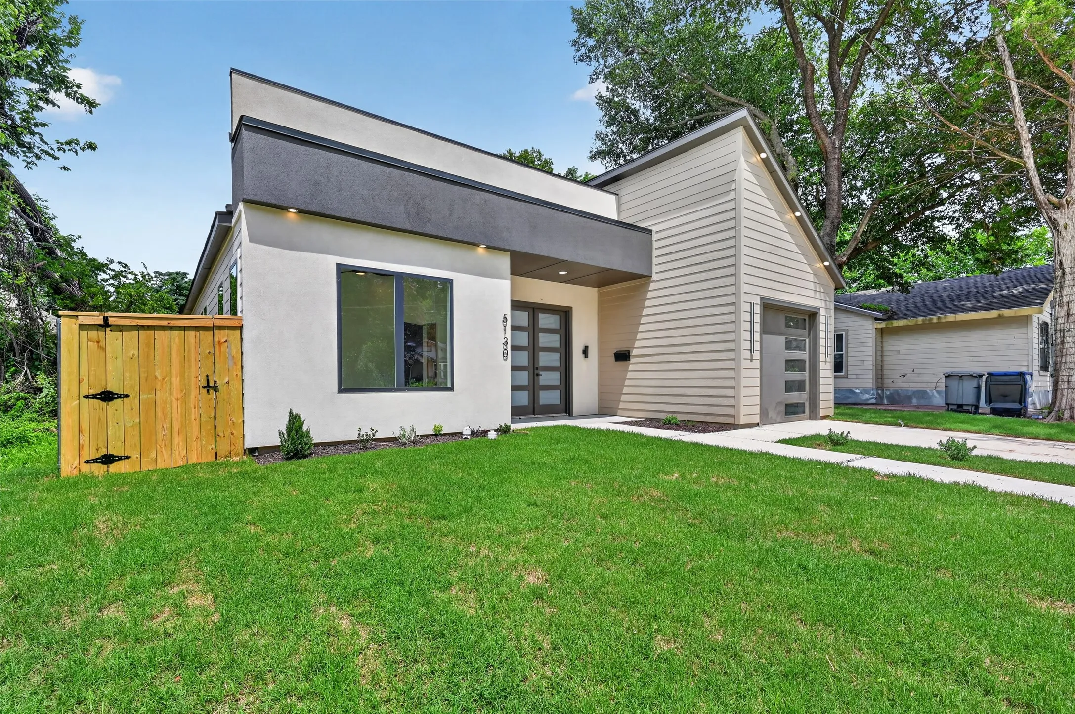 Contemporary exterior featuring a flat roofline, stucco facade, and horizontal siding accents