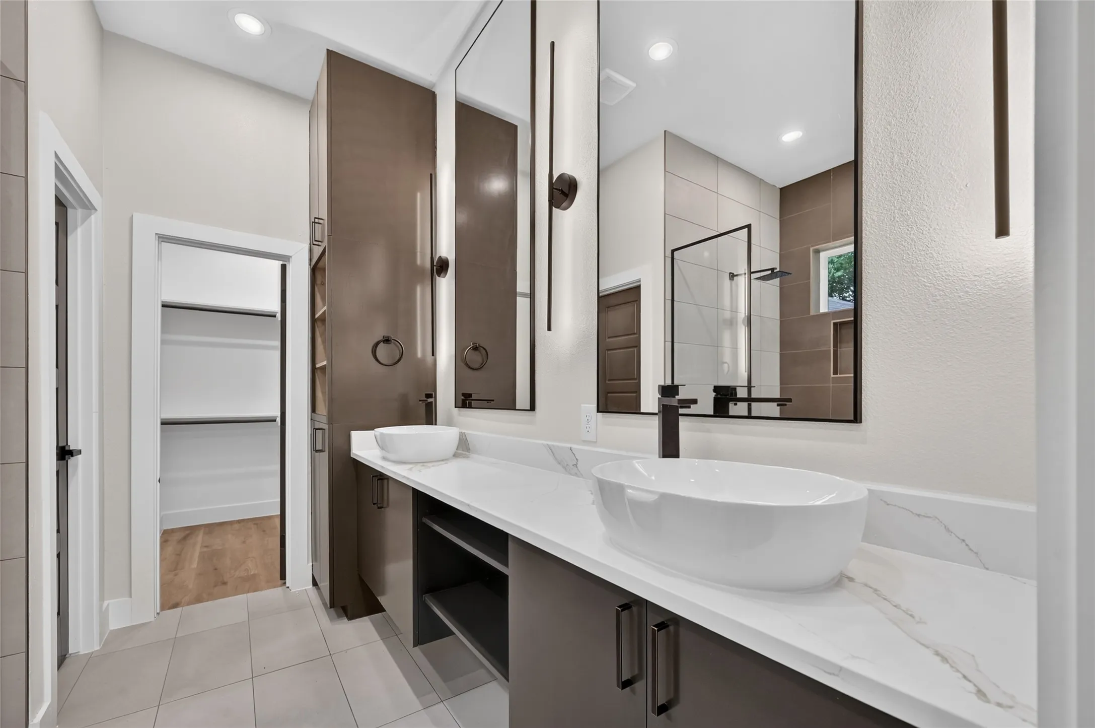Double vanity with vessel sinks, quartz countertops, dark wood-finish cabinetry, and contemporary lighting