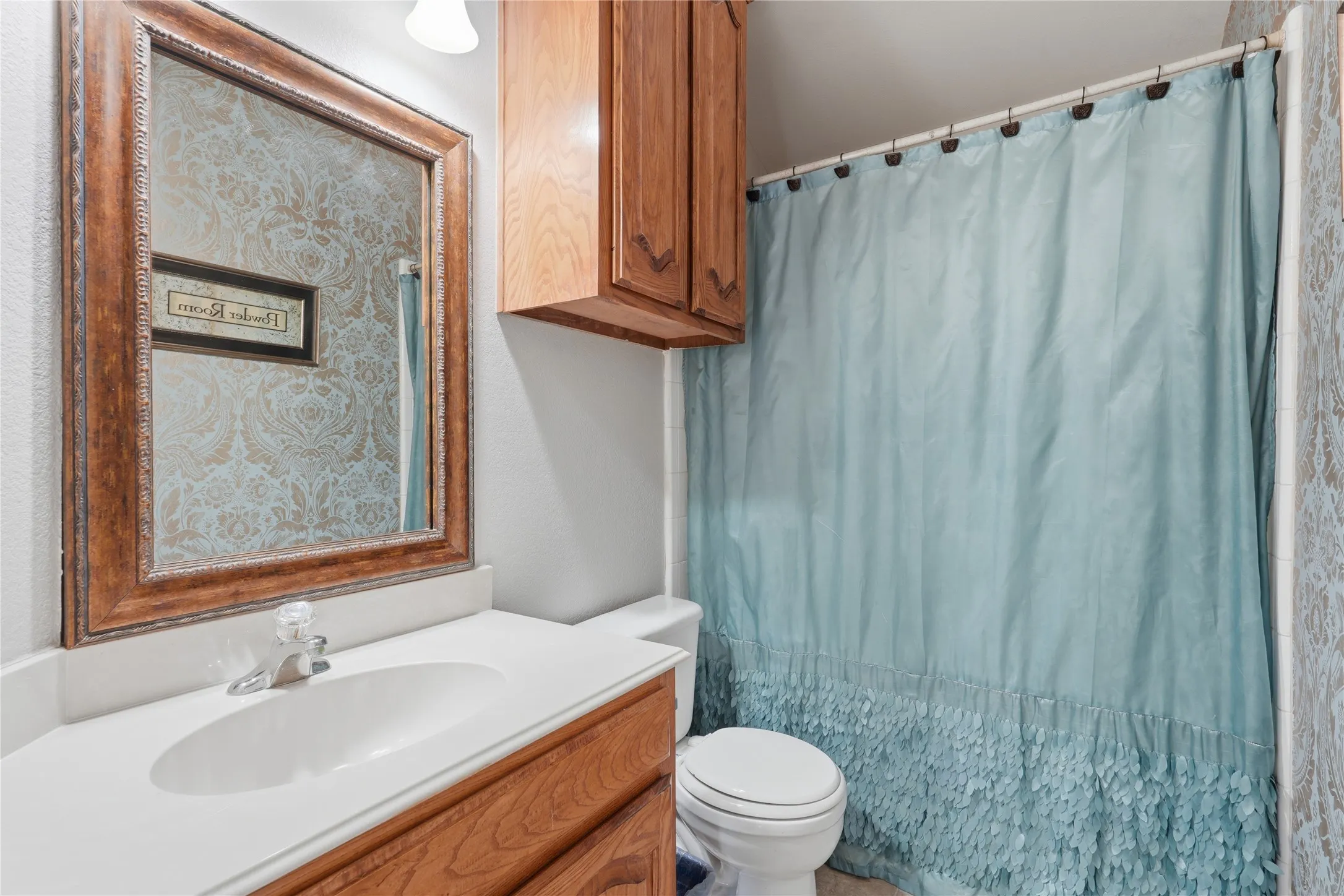 Bathroom vanity featuring a white countertop, an integrated sink, and wood-finish cabinetry