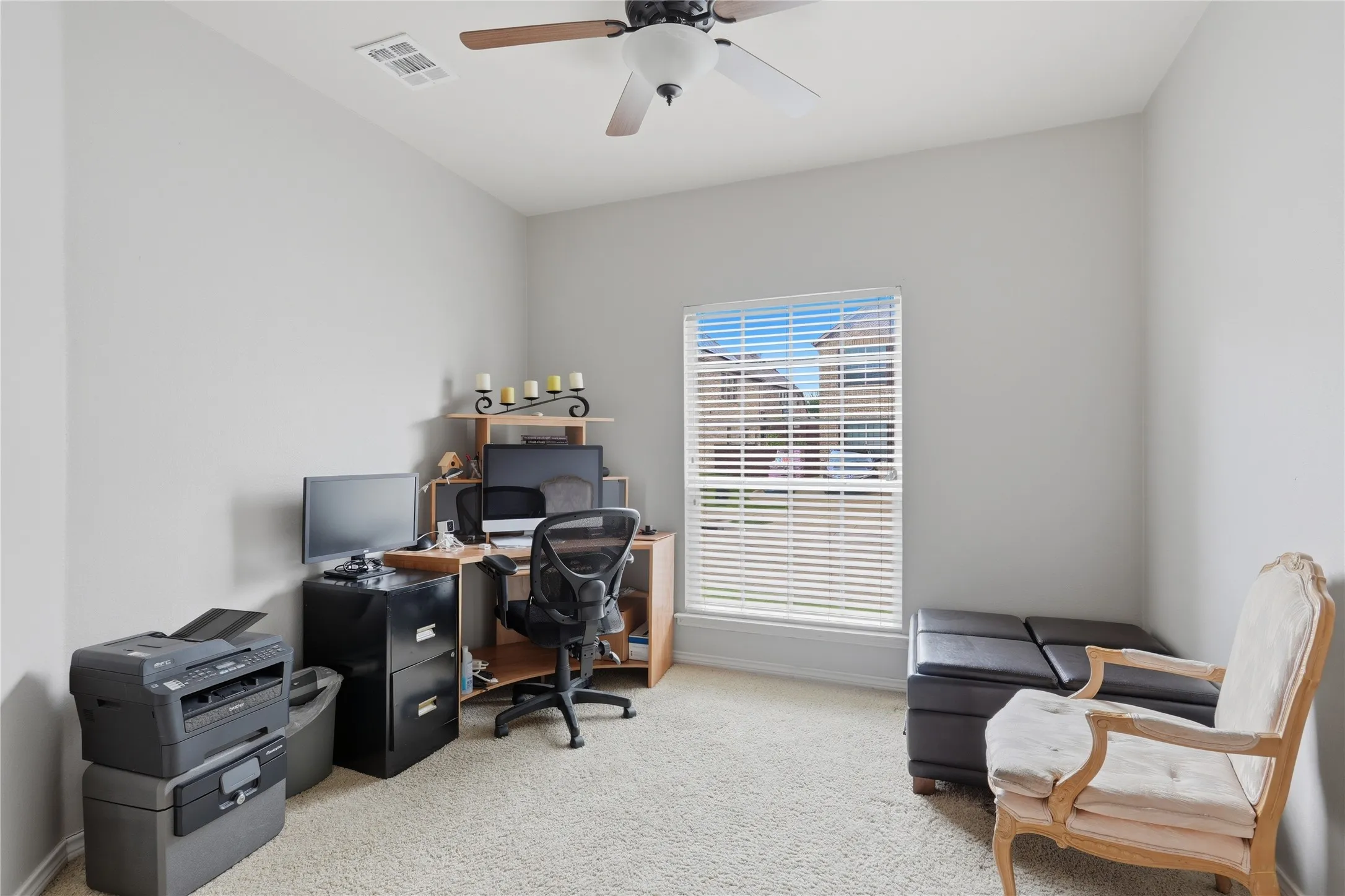 Carpeted room with a ceiling fan, a window with horizontal blinds, and neutral-toned walls