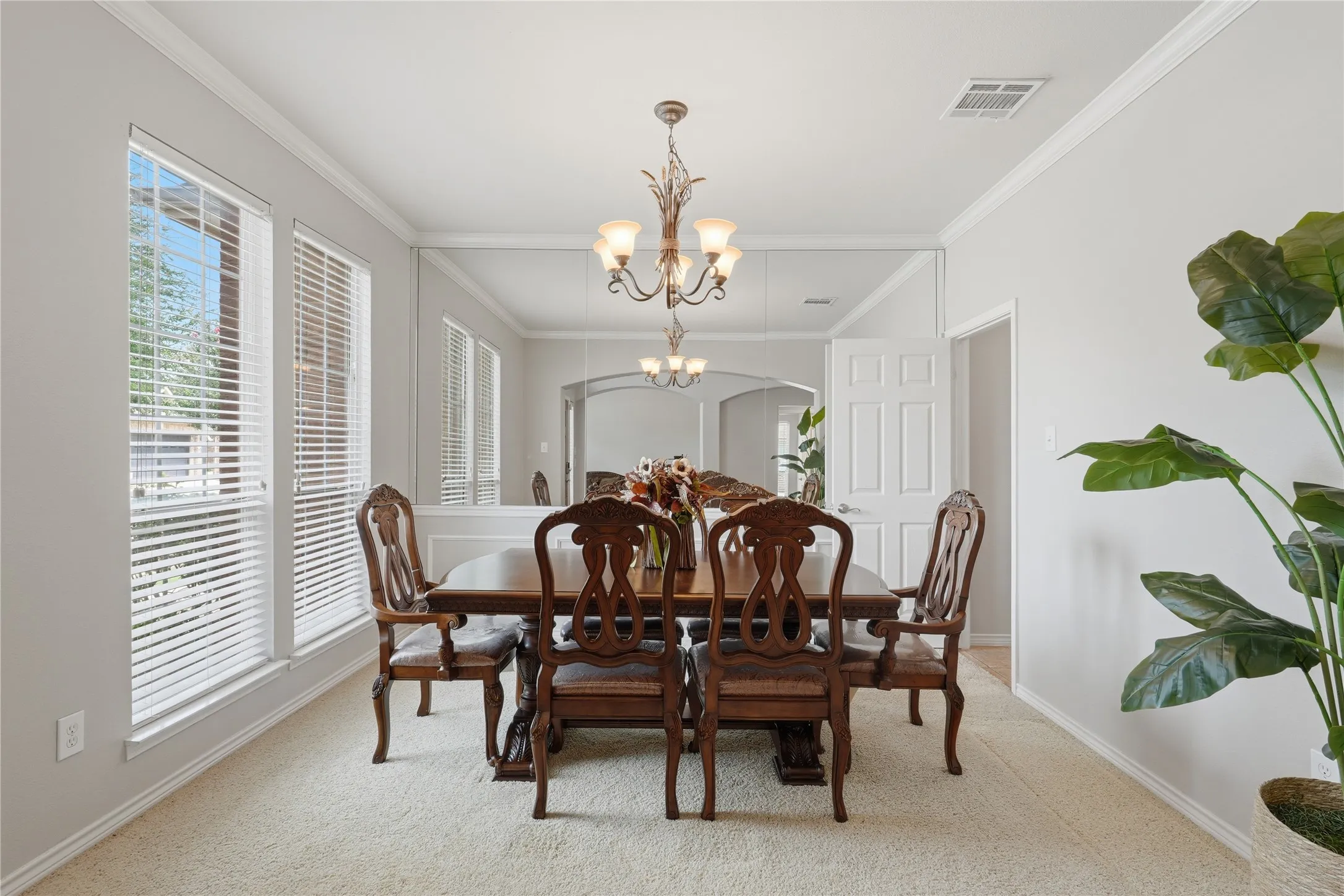 Formal dining area featuring a decorative chandelier and multiple windows with blinds