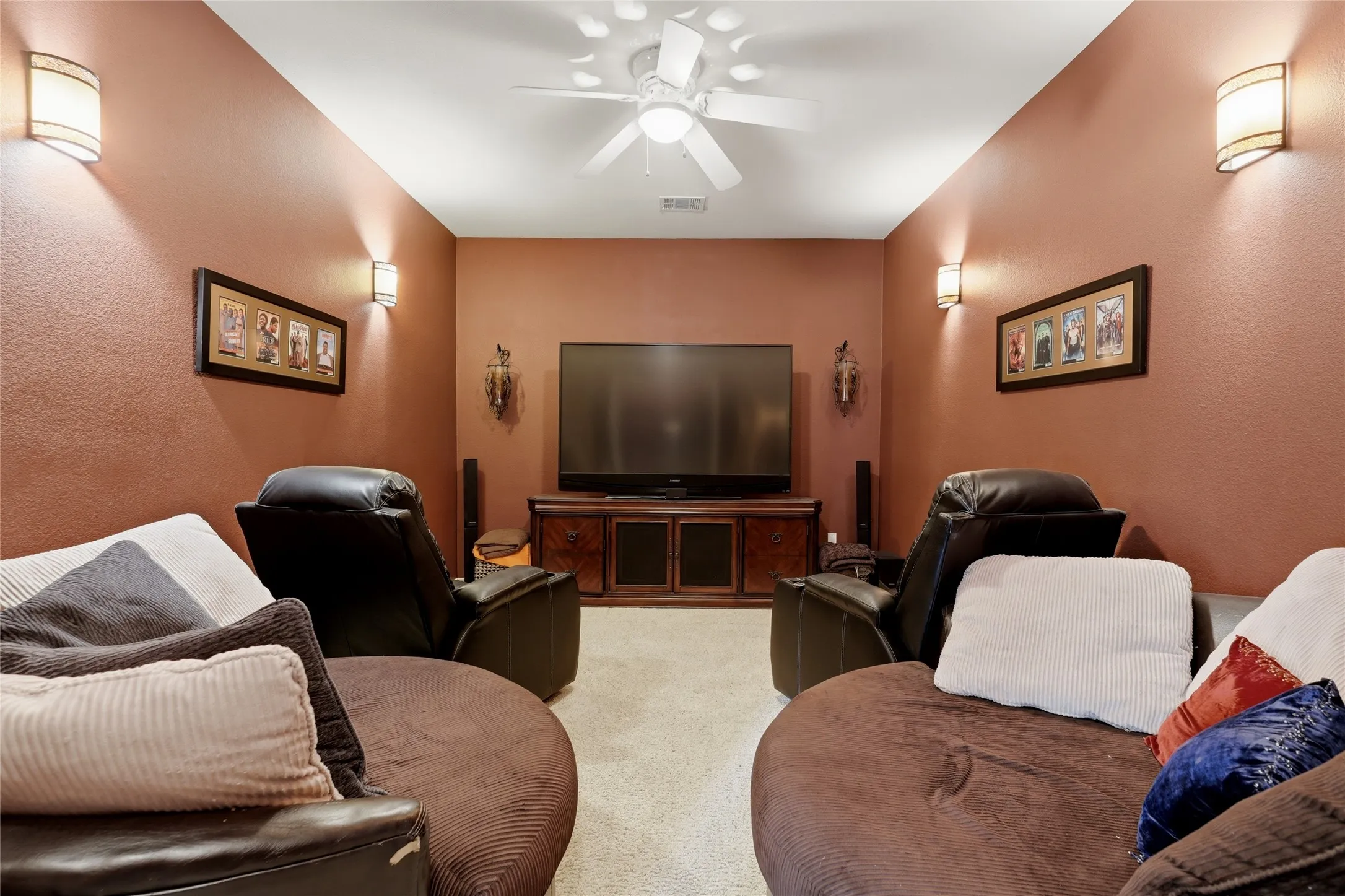 Dedicated media room featuring recessed lighting, a ceiling fan, sconce lighting, and a built-in media console