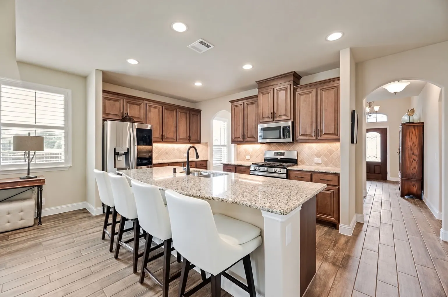 Nice Size Open Kitchen with so many Great Features for Family or Entertaining - Much Cabinet and Counter Space. Recessed Lighting, Granite Countertops and Travertine Back Splash - Large Island with Stainless Double Sink, GE Gas Range with Griddle, Vented, GE Microwave, Bosch Dishwasher 2024, the 2021 LG Thin Q Door in Door Refrigerator to remain.