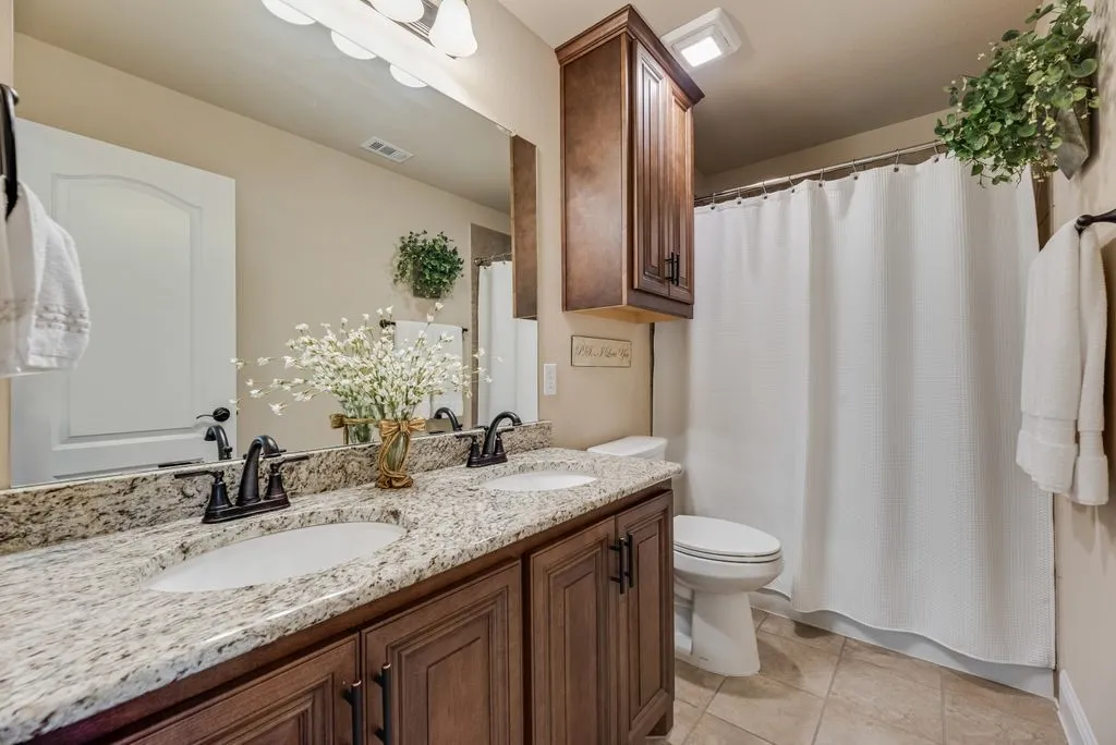 This photo is the 2nd Full Bath - located off the Landing for bedroom 2 and 3. Double Vanity - Cabinet over Commode, Tile Surround in Tub Shower Combination. Ceramic Tile Flooring, Added Cabinet Hardware after build 2021.