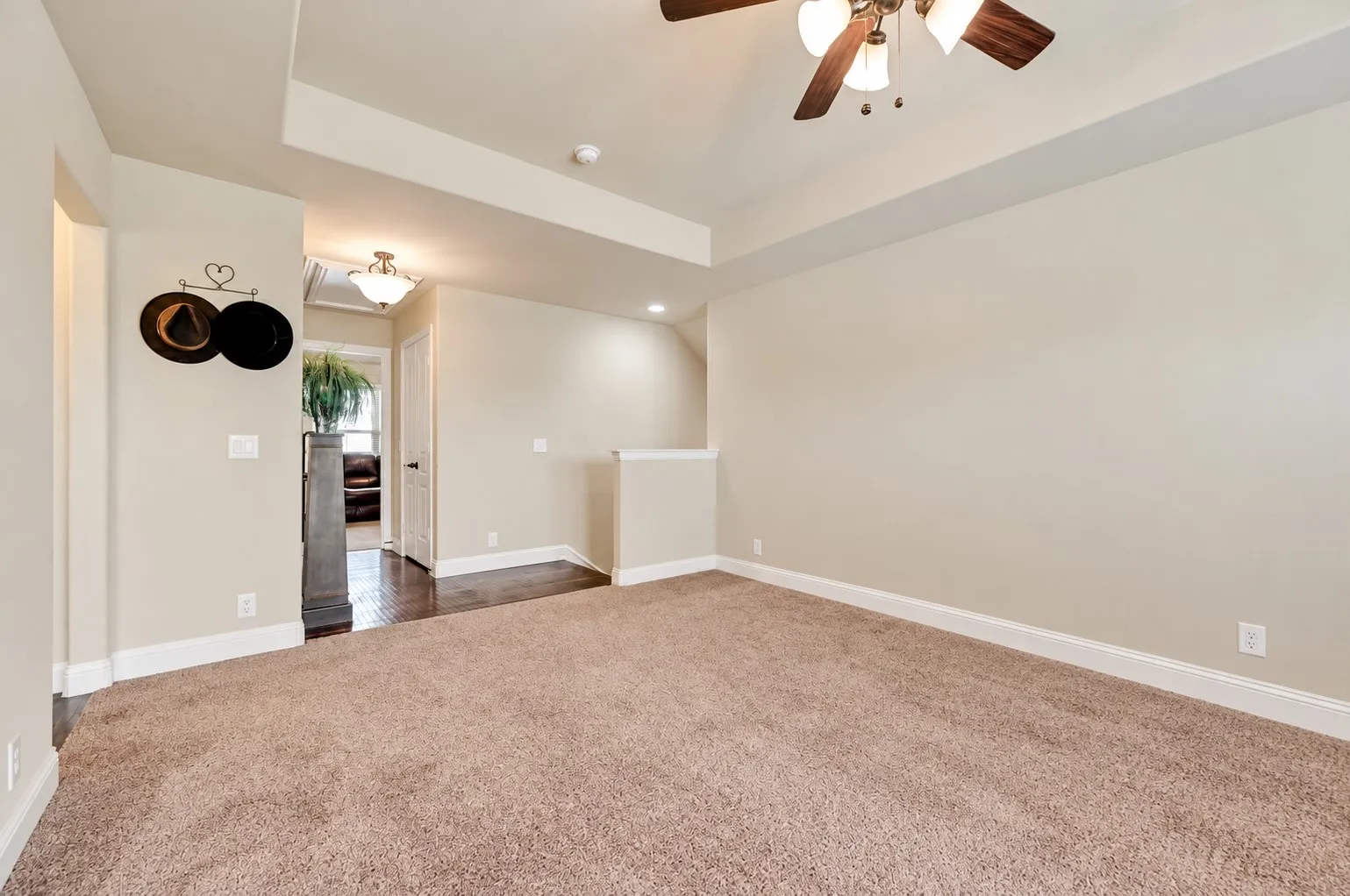 Partial View of 2nd Living, Game Room, Flex Room - with view of the Landing - The Landing and Hall to 2nd and 3rd bedroom and 2nd Full Bath is the Hand Scraped Wood Flooring from Builder 2021. The Decorative Lighting was added in 2021 after the build. A pull Down Attic Access is in the Hallway. The Entry Hall to the left of the 2nd Living Areas has the same Wood Flooring - and leads to the 3rd full bath and 4th Bedroom.