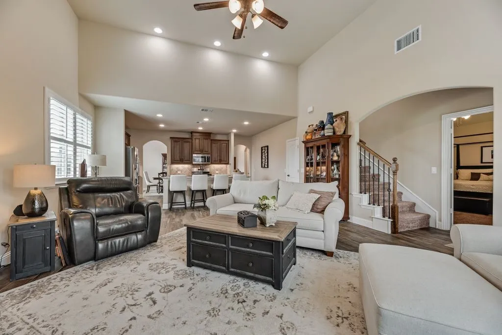 Partial Views- Family Area, Kitchen, Stairs, and Entry of Primary Bedroom. Archways, Raised, Vaulted Ceilings, Wood and Wrought Iron Spindle Staircase.