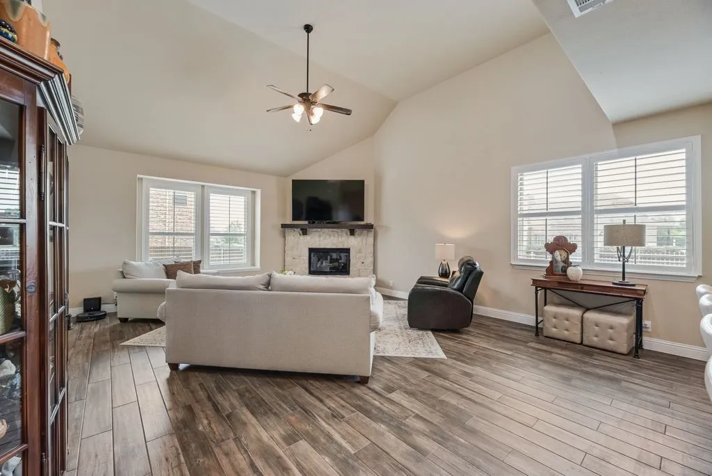 Partial View of Cafe Area and First Level Living Area with Stone Fireplace - Gas Key Turn On, Gas Logs with Remote Start, Glass Front Cover. Raised Vaulted Ceiling, 3.5 inch Shutter Blinds shown in this photo