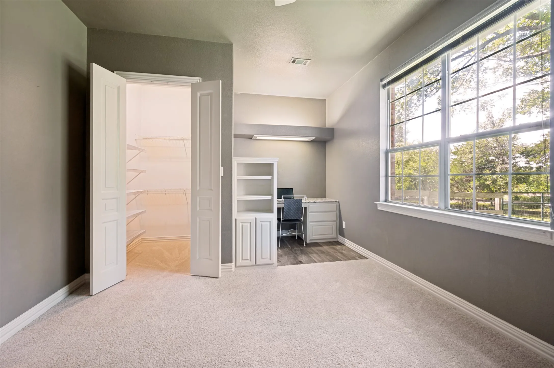 Downstairs secondary bedroom with walk in coset and built in desk and bookshelf.  Bathroom right next door.