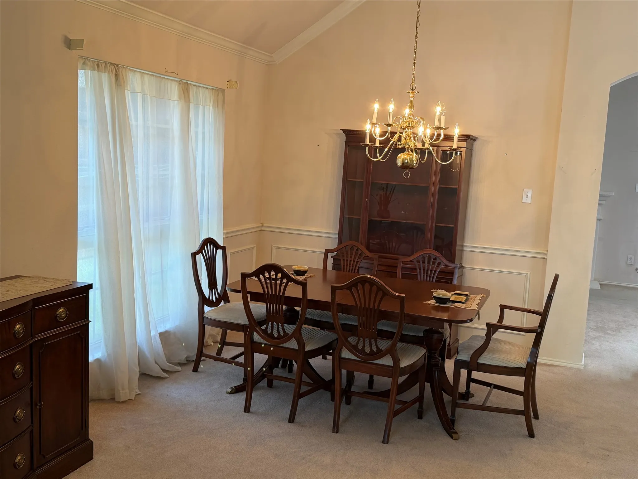 Formal dining area featuring a vaulted ceiling with a chandelier