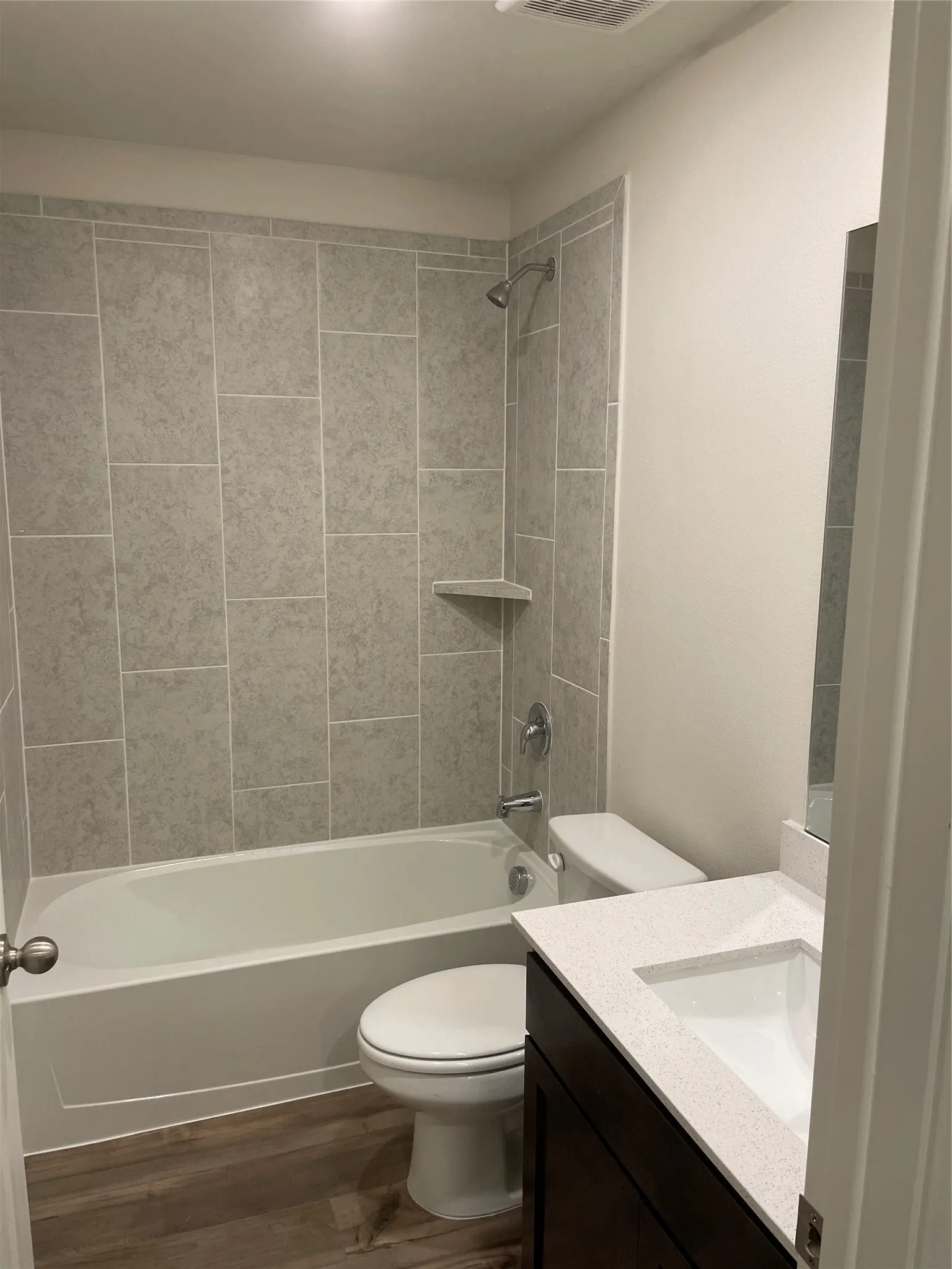 Bathroom featuring a white bathtub, light grey subway-style tile surround, and a chrome shower head with coordinating fixtures