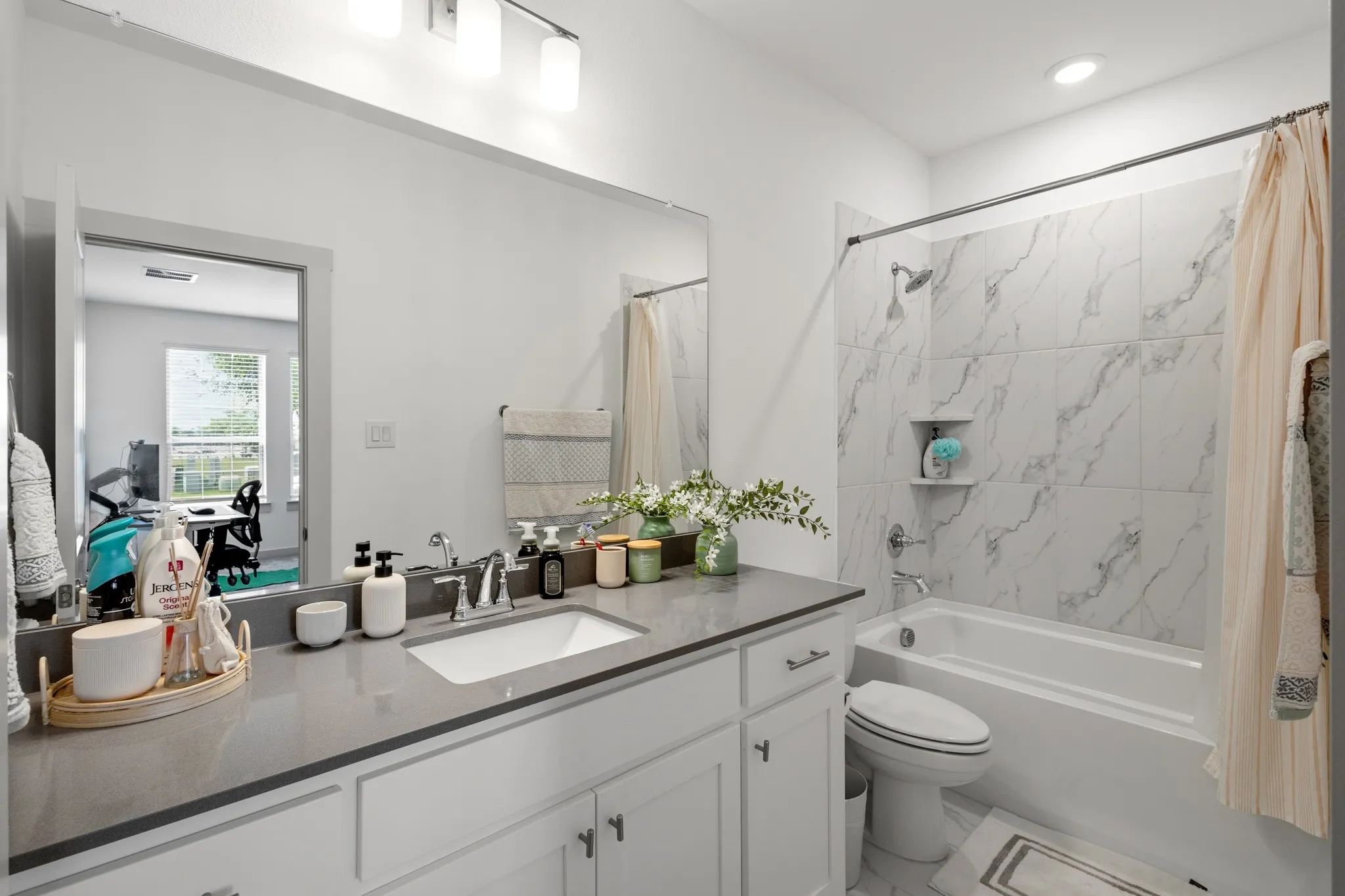 Primary bathroom showcasing an expansive dual vanity with quartz countertops, framed mirrors, and an elegant design that elevates your morning and evening routines.