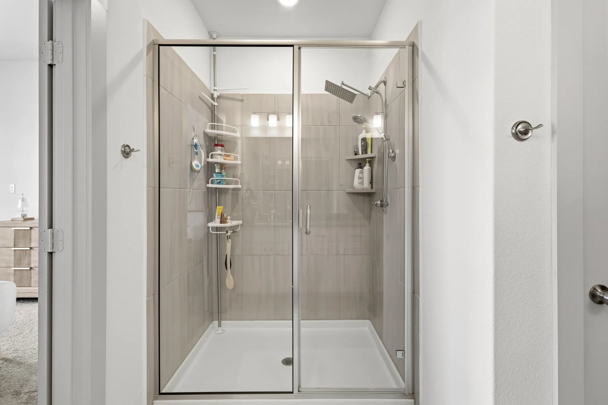 Primary bathroom glass-enclosed shower with premium tile surround, frameless door, and thoughtfully designed for both style and function -- a resort-like experience at home.