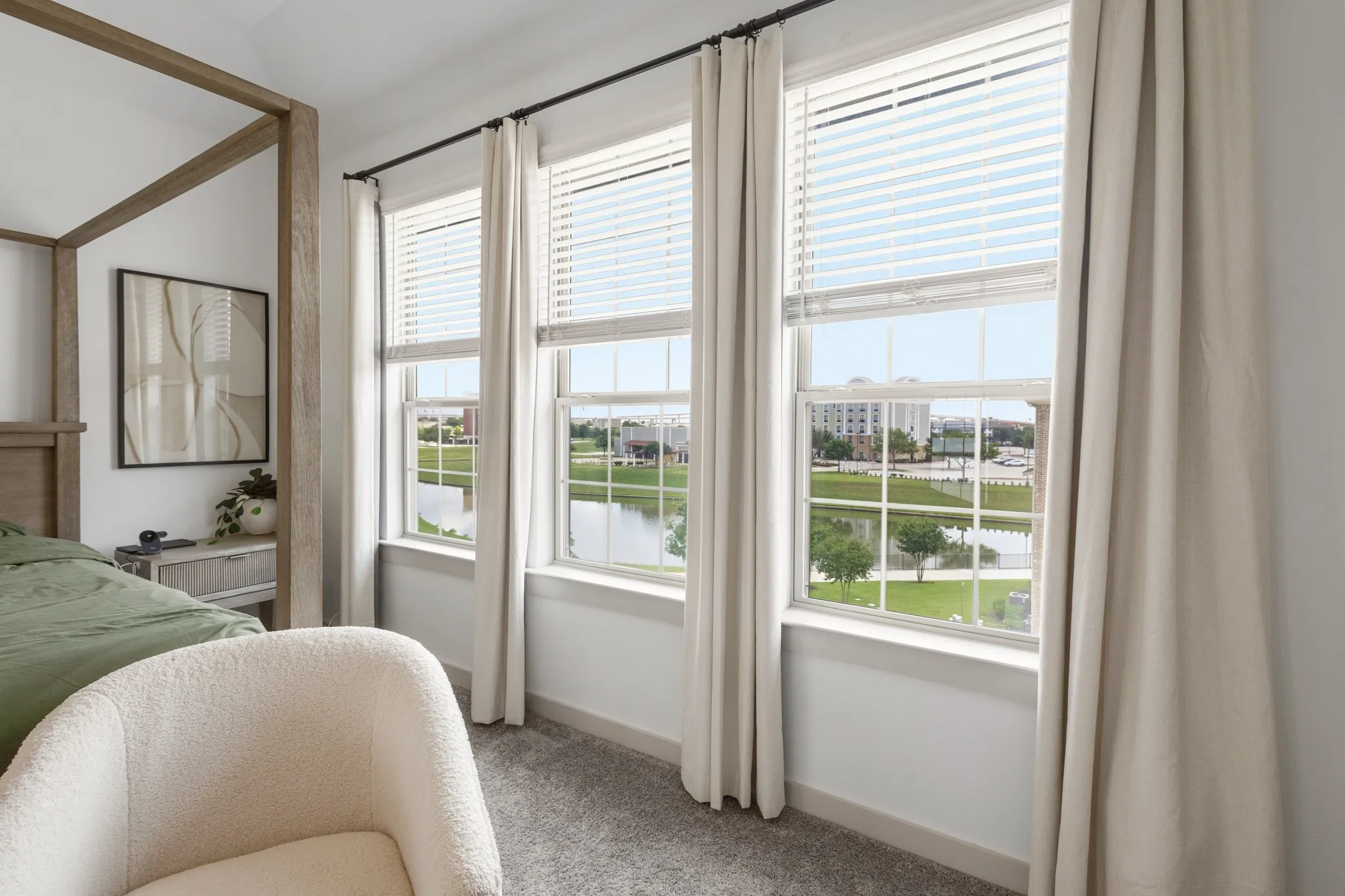 Primary bedroom with large windows flooding the room with natural light, high ceilings, and a peaceful ambiance -- serene canal views create the perfect retreat after a long day.