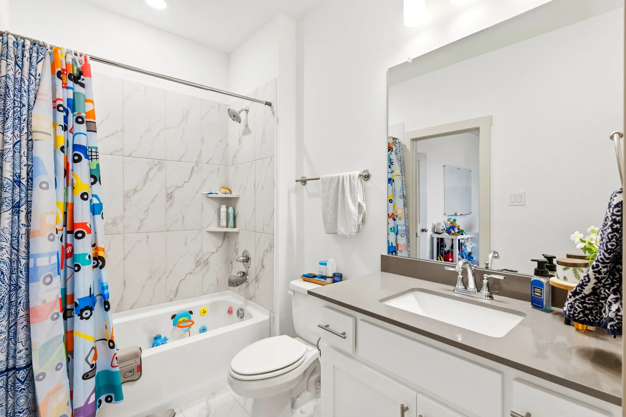 Full secondary bathroom serving the lower-level bedrooms, featuring a tub-shower combination, single vanity, and clean tile design -- functional and ready for family or guests.