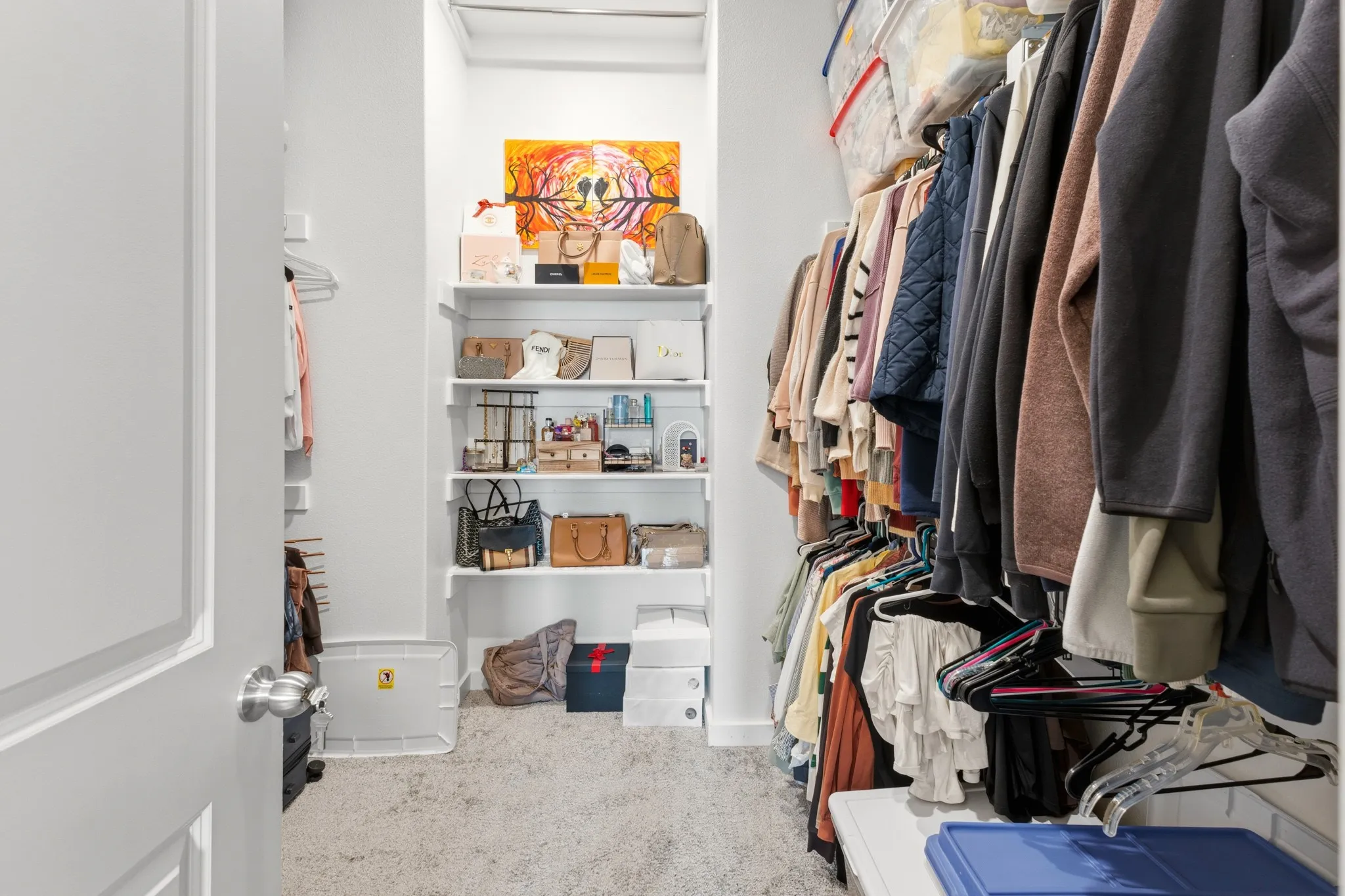 Walk-in closet adjacent to the primary suite featuring generous hanging space and built-in shelving -- providing ample storage to accommodate even the most extensive wardrobe.