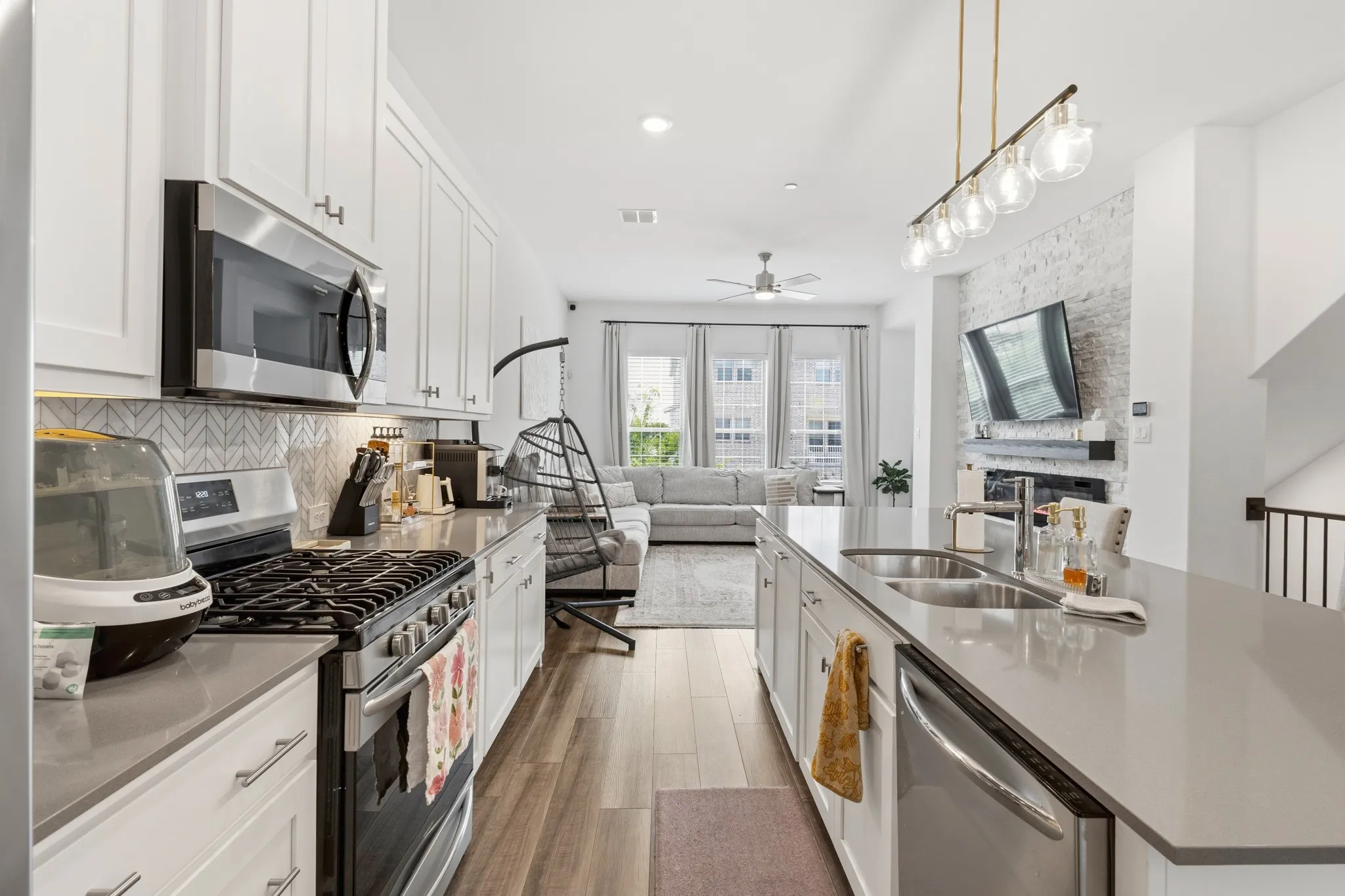 Spacious kitchen with wood-finish luxury vinyl plank flooring, white shaker cabinetry, ample counter space, and a sleek modern design that makes everyday cooking a pleasure.