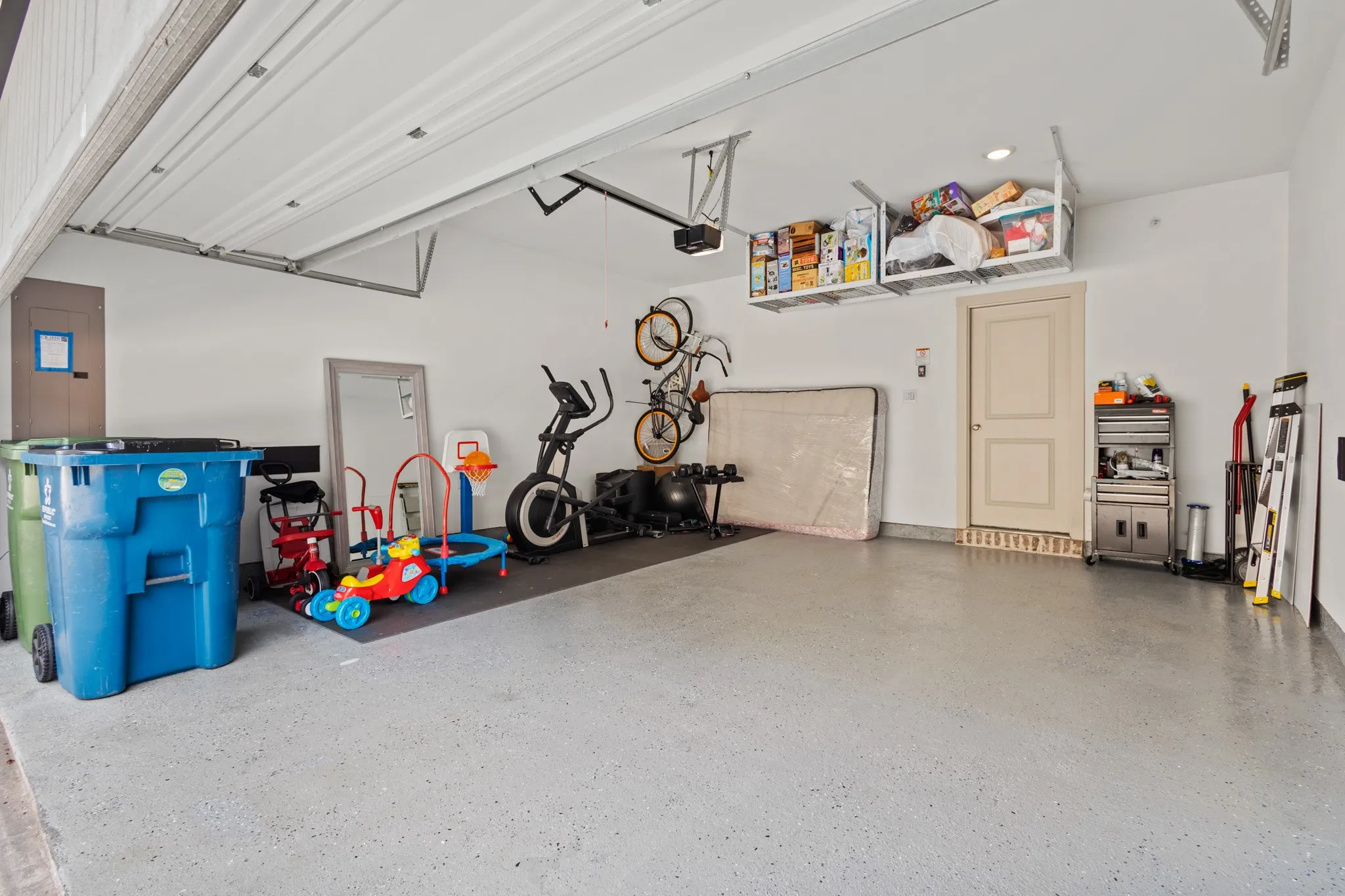Oversized 2-car garage offering ample room for vehicles and additional storage, with polished epoxy floors and overhead lighting -- a functional and impressive space.