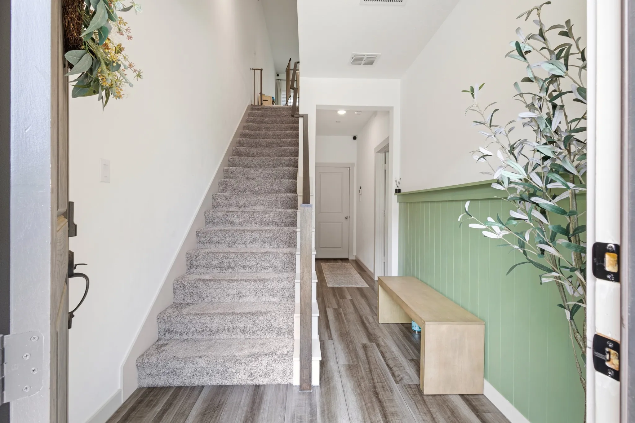 Beautifully finished staircase with wood-look treads and crisp white risers, elegantly connecting all three levels of this thoughtfully designed 3-story townhome.