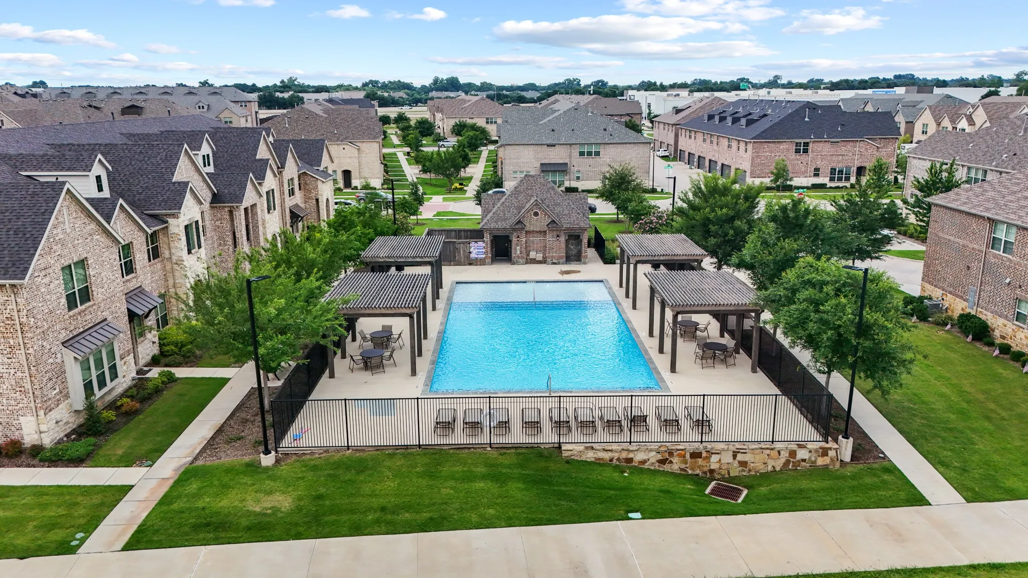 Resort-style community swimming pool and integrated spa surrounded by lush landscaping and comfortable lounge areas -- a premium HOA amenity just steps from your front door.