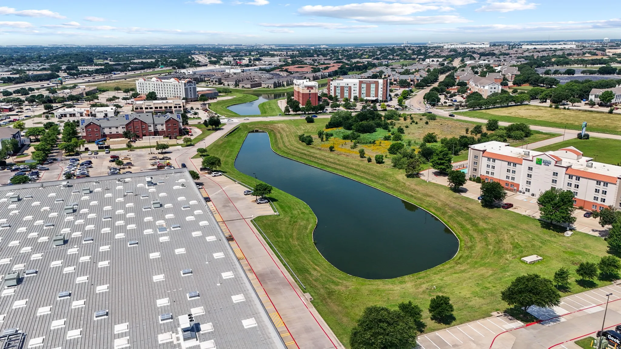 Aerial perspective of the scenic canal and community greenspace at Vista Del Lago, offering a peaceful natural setting just steps from your front door.