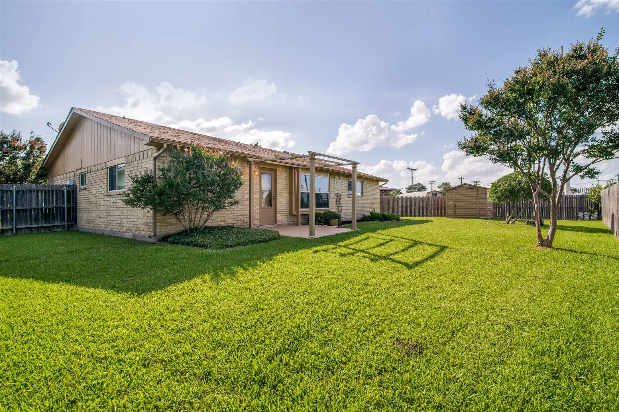 Manicured lawn and metal storage shed on nearly .4 an acre